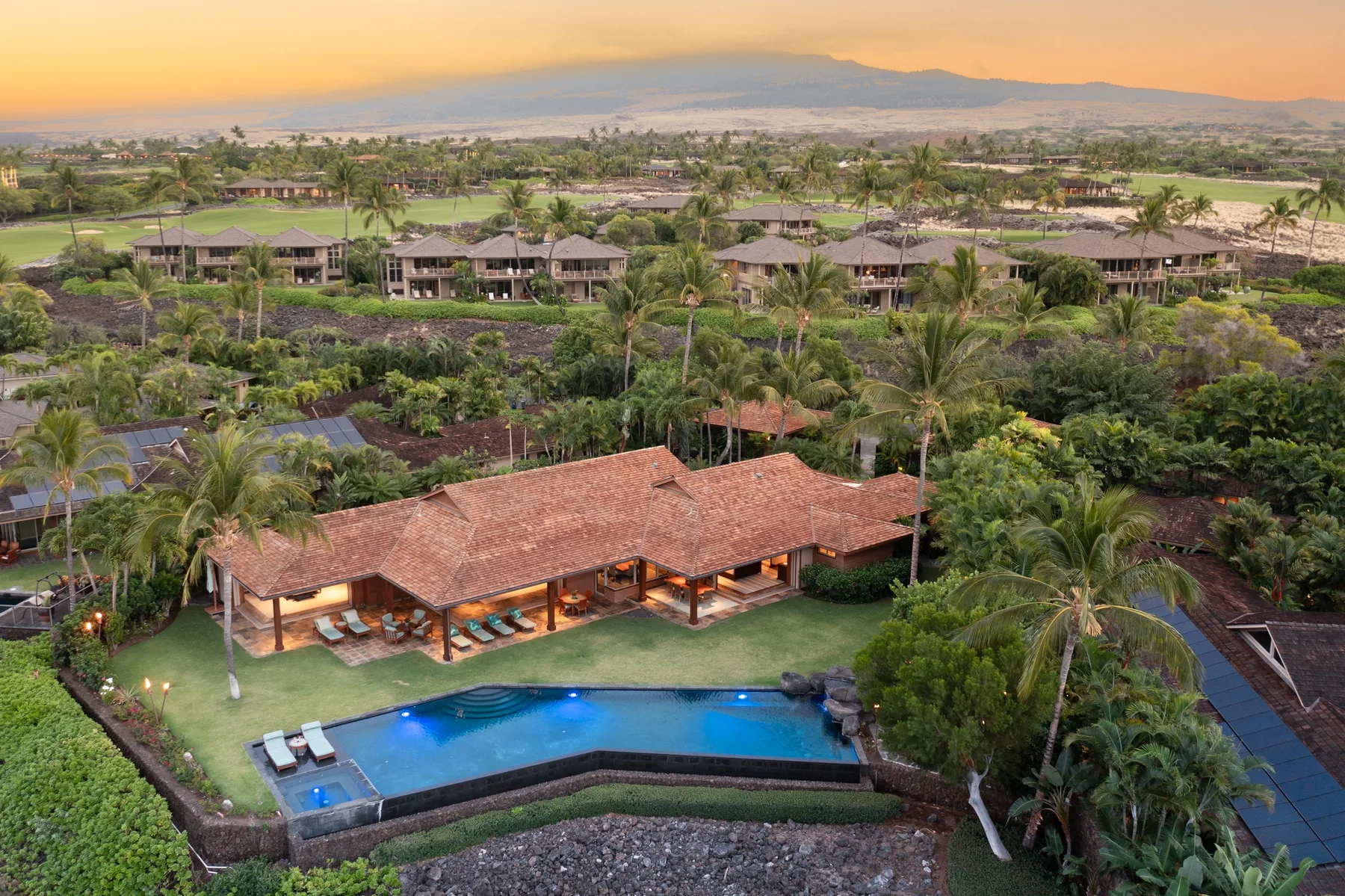 Aerial view of a resort pool and pavilion amid tropical landscaping.