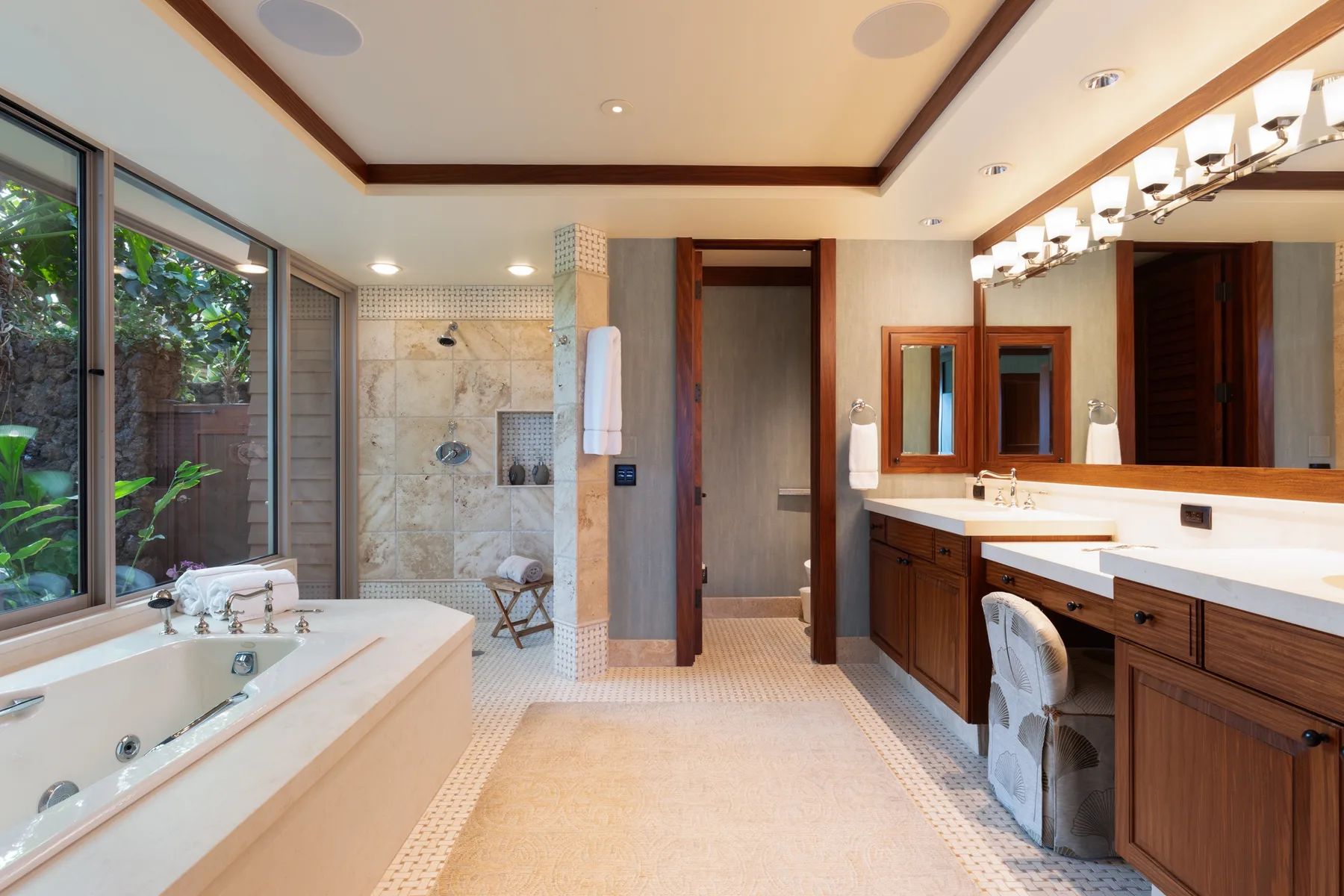 A spacious bathroom with a bathtub, walk-in shower, and long vanity.