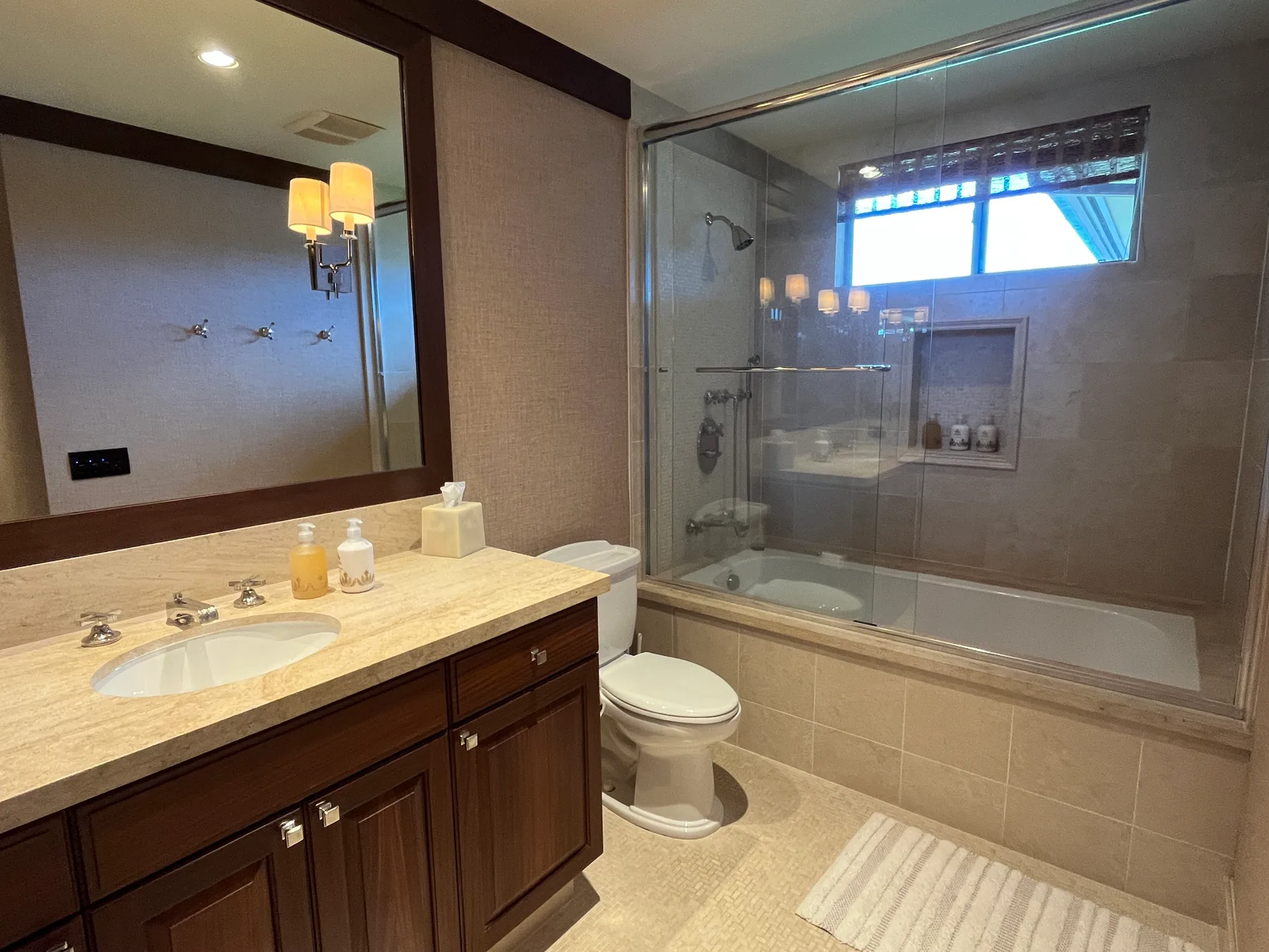 A bathroom with a vanity, toilet, and glass-enclosed shower.