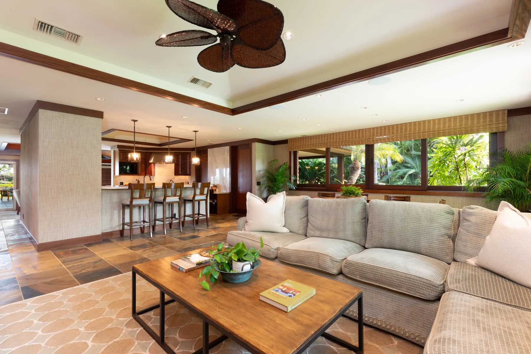 An open living room with a sectional seating area and dining counter.