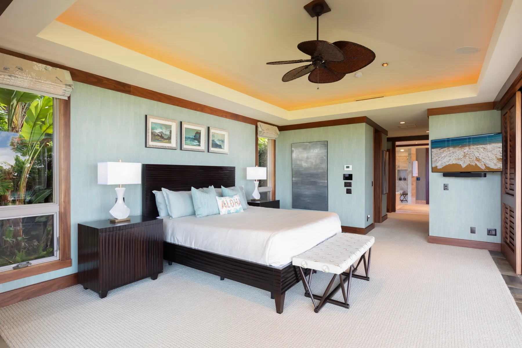 A bedroom with a large bed, bedside tables, and a ceiling fan.