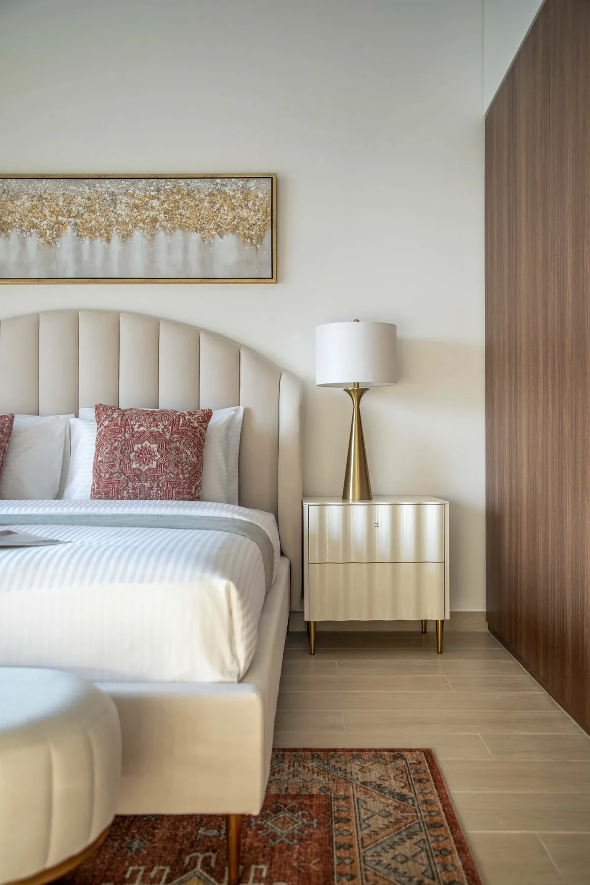 Un dormitorio con una cama tendida y un cuadro enmarcado encima.