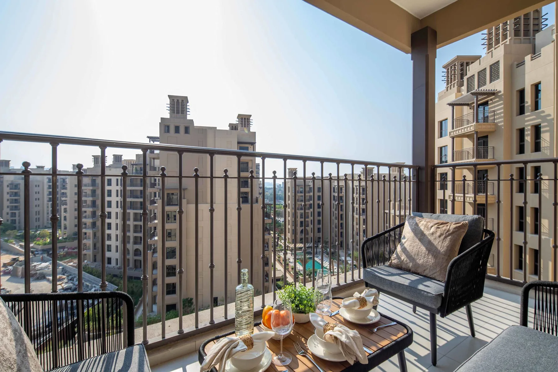 Una zona de estar en el balcón tiene vistas a edificios de apartamentos cercanos.