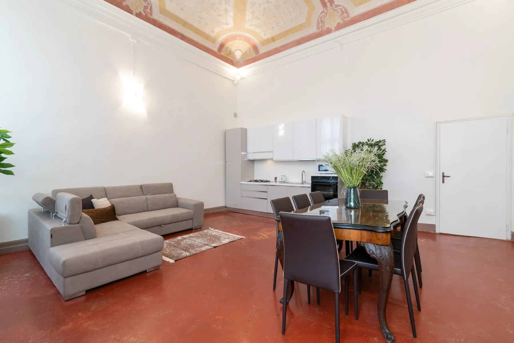 Un salón-comedor con un sofá seccional y una mesa de comedor.