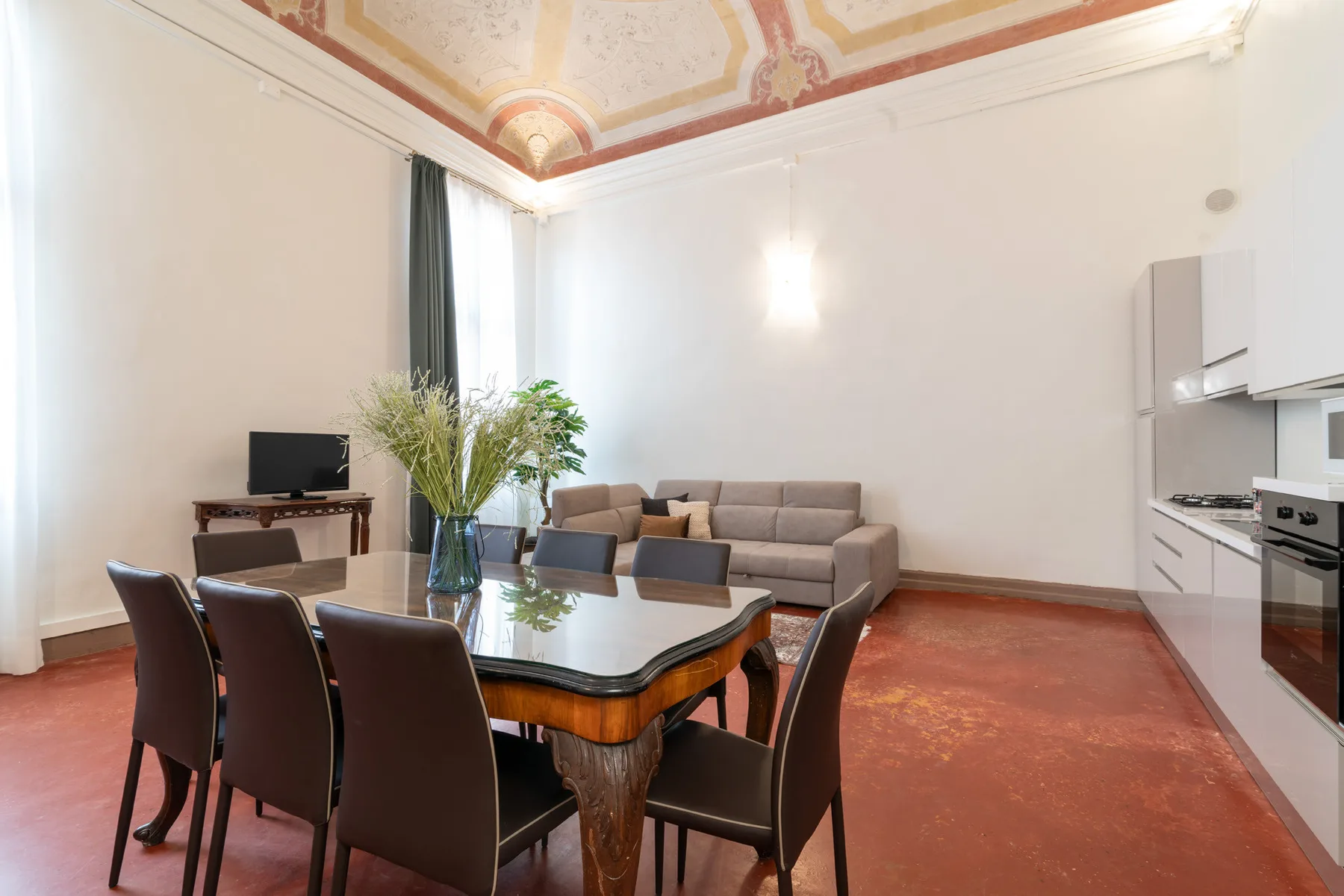 Comedor con mesa y sillas junto a una cocina compacta.