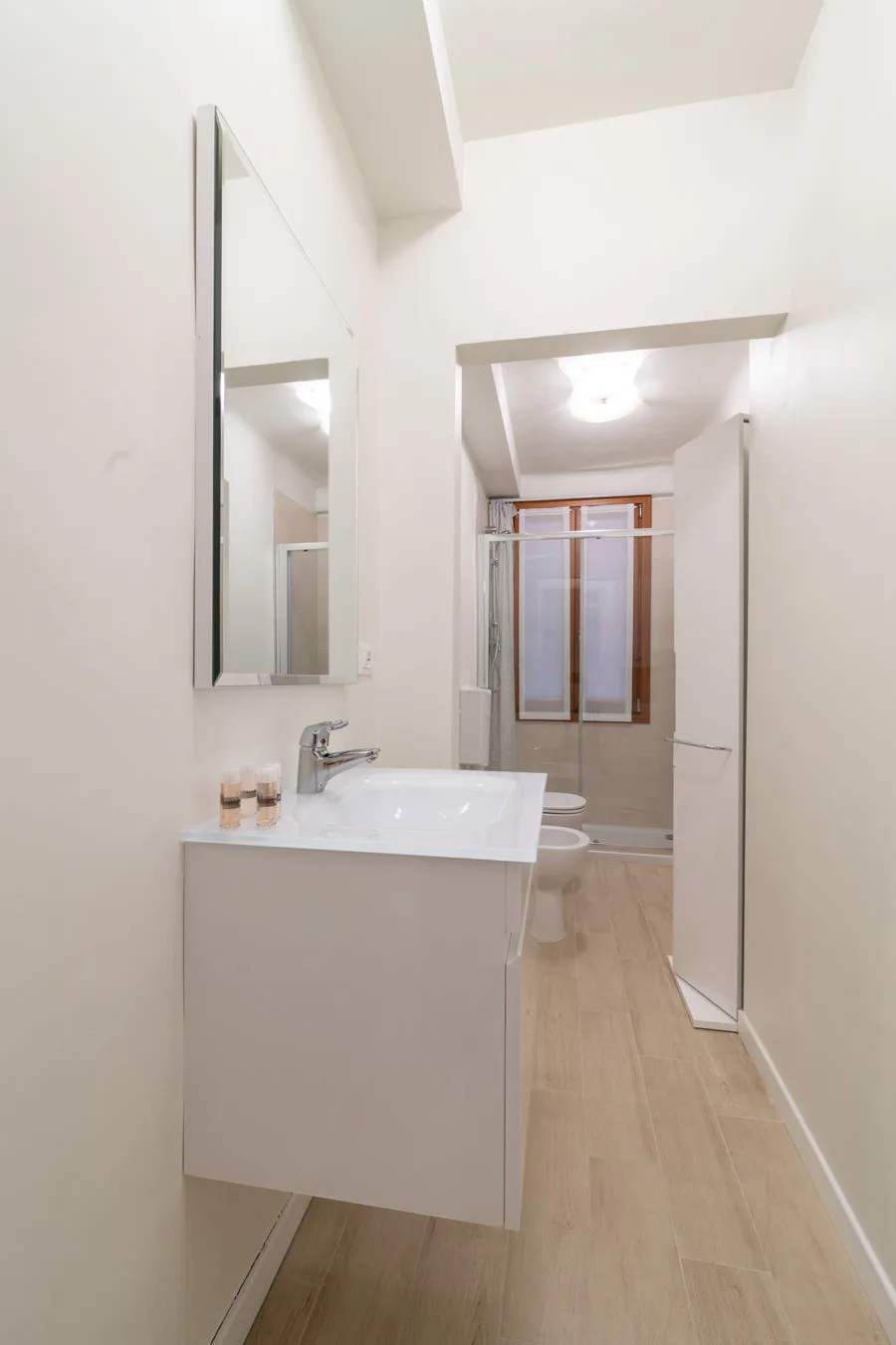 Un baño luminoso con lavabo, espejo y bañera.