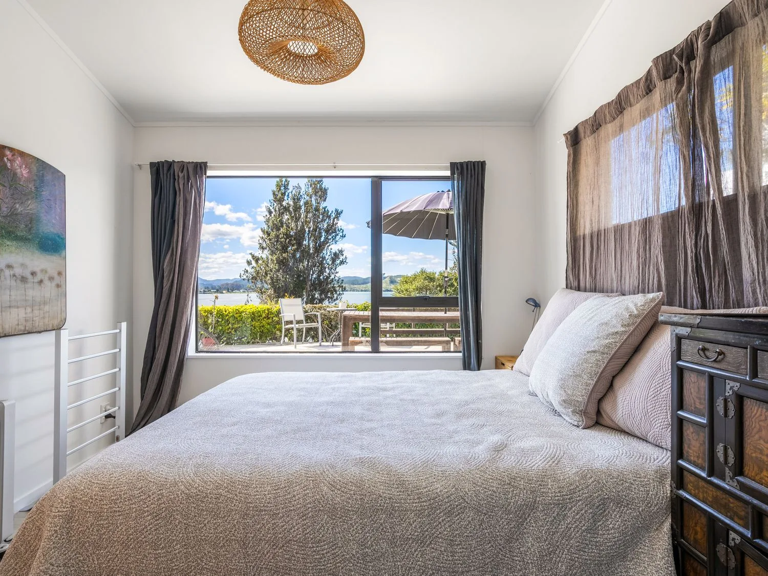 A bedroom with a bed and window view at Harbour house - Whangamata Holiday Home