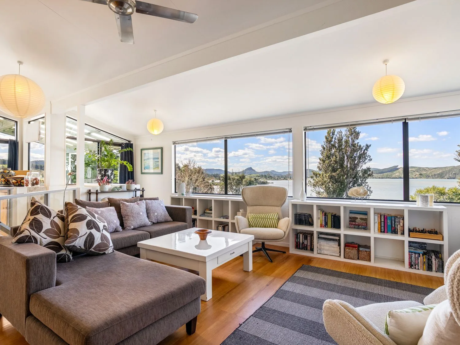 A living room with a sofa and coffee table at Harbour house - Whangamata Holiday Home