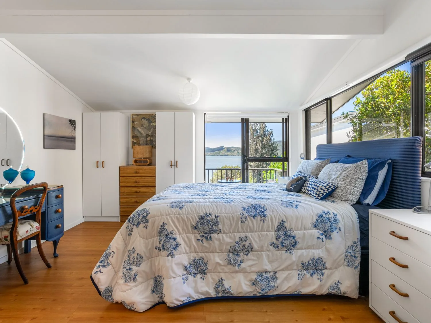 A bedroom with a bed and wardrobe at Harbour house - Whangamata Holiday Home