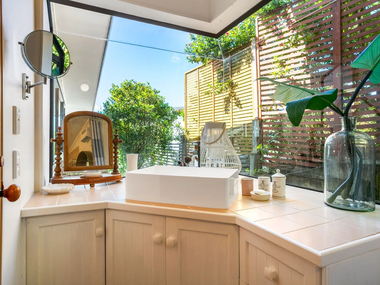 A bathroom with a sink and mirror at Harbour house - Whangamata Holiday Home