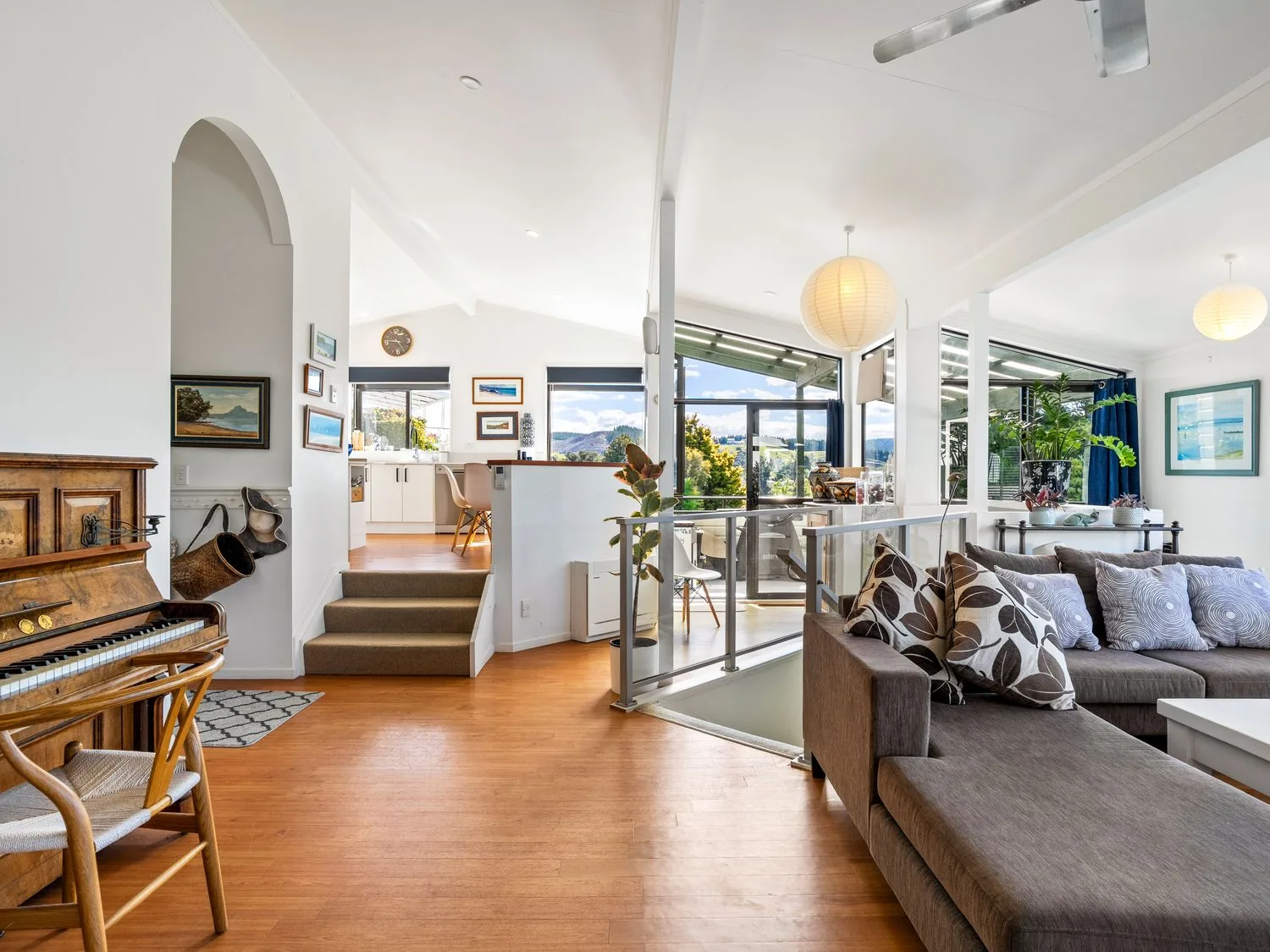 A living room with a piano and a sofa at Harbour house - Whangamata Holiday Home
