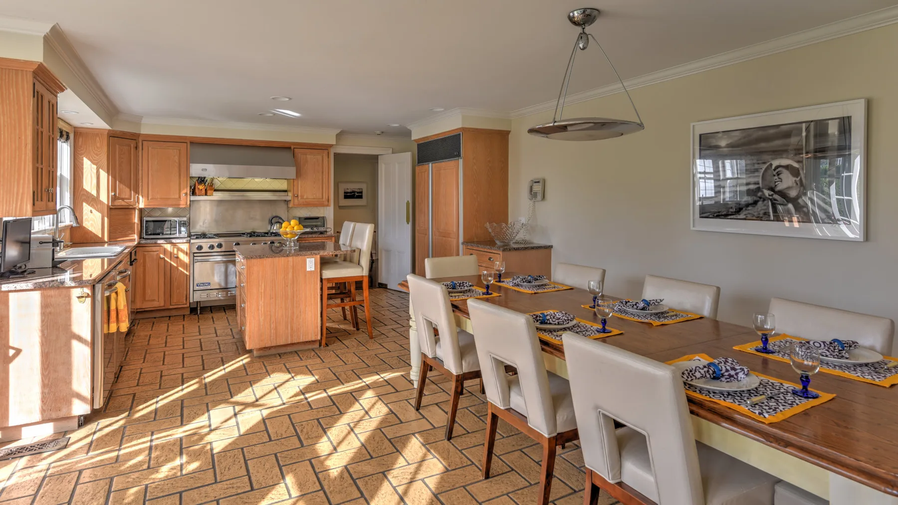 A kitchen and dining area with wooden cabinets and a long dining table.