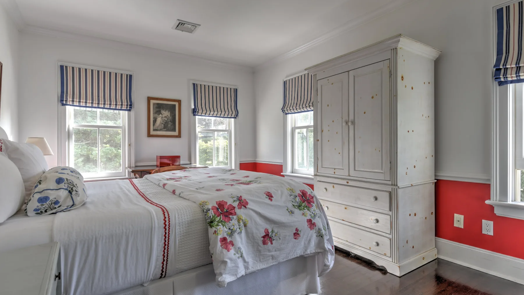 A bedroom with two beds and a large white wardrobe.