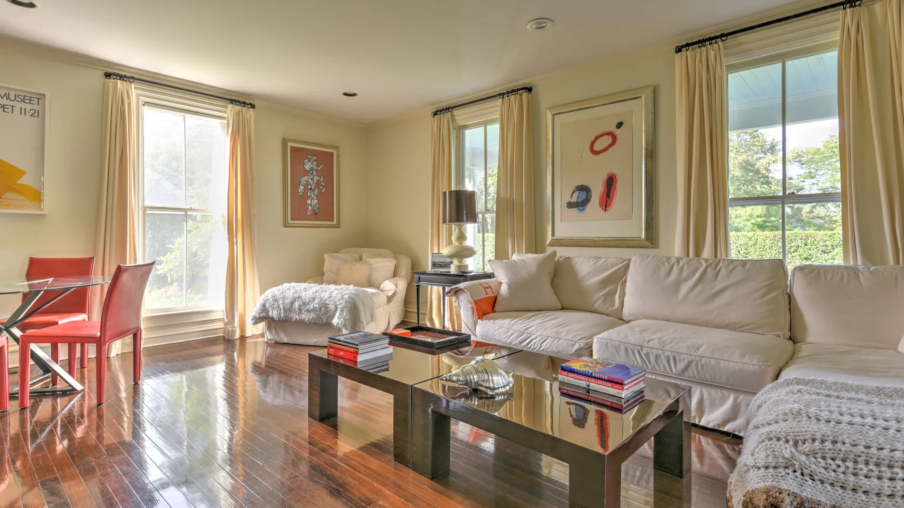 A living room with seating, a coffee table, and tall windows.
