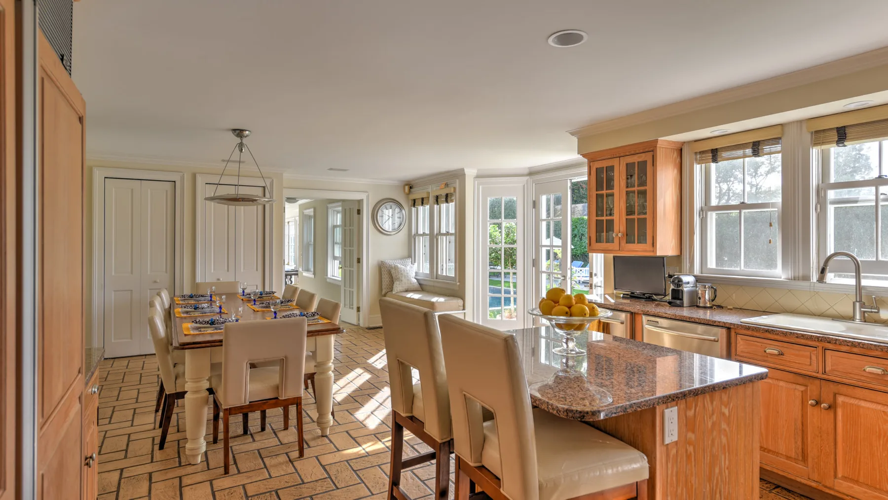 A bright kitchen and dining area with a central island and dining table.