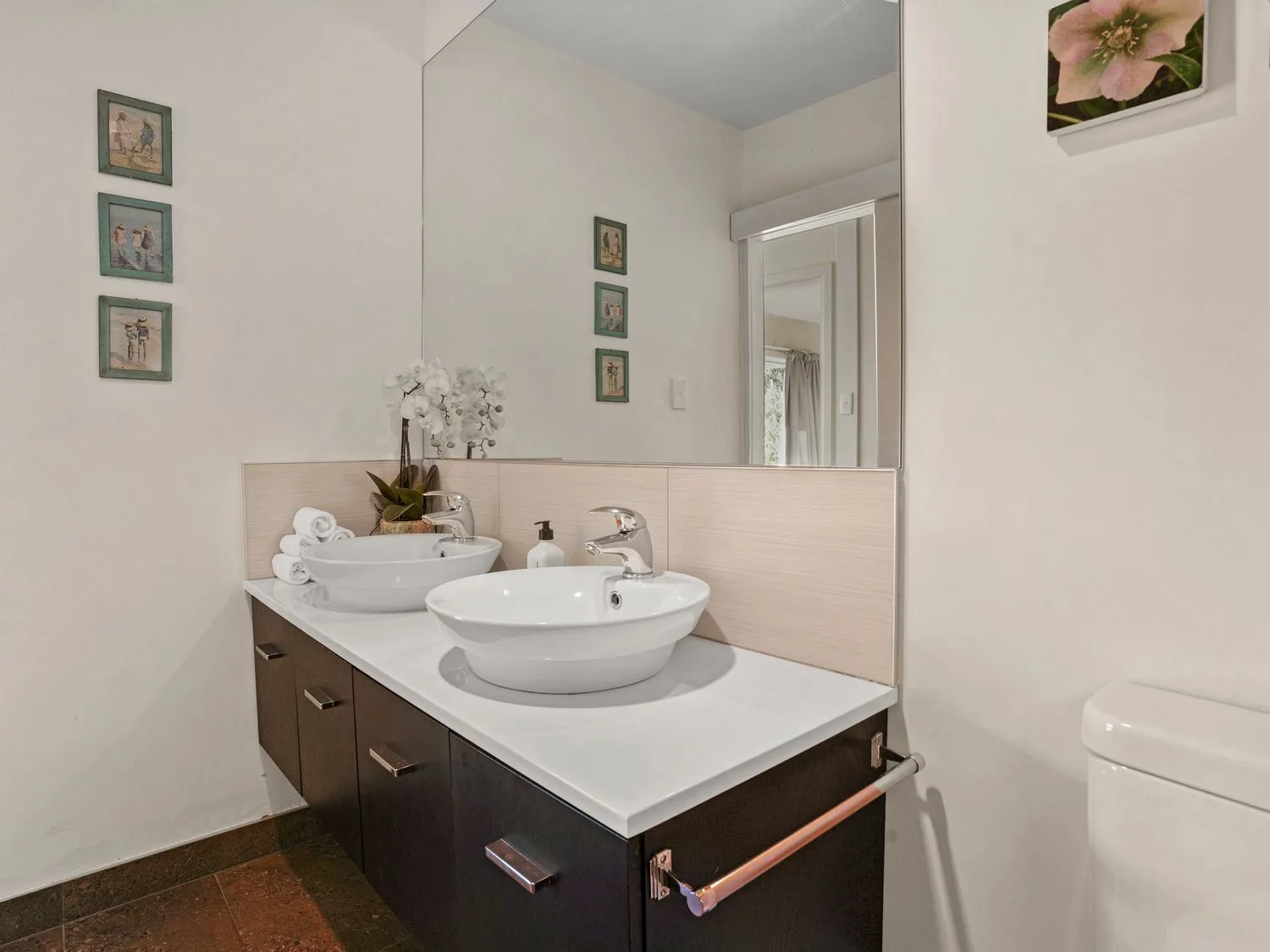 Un baño con dos lavabos y un espejo grande sobre la encimera en Kaioruru View Diamond Harbour Holiday Home, en Diamond Harbour