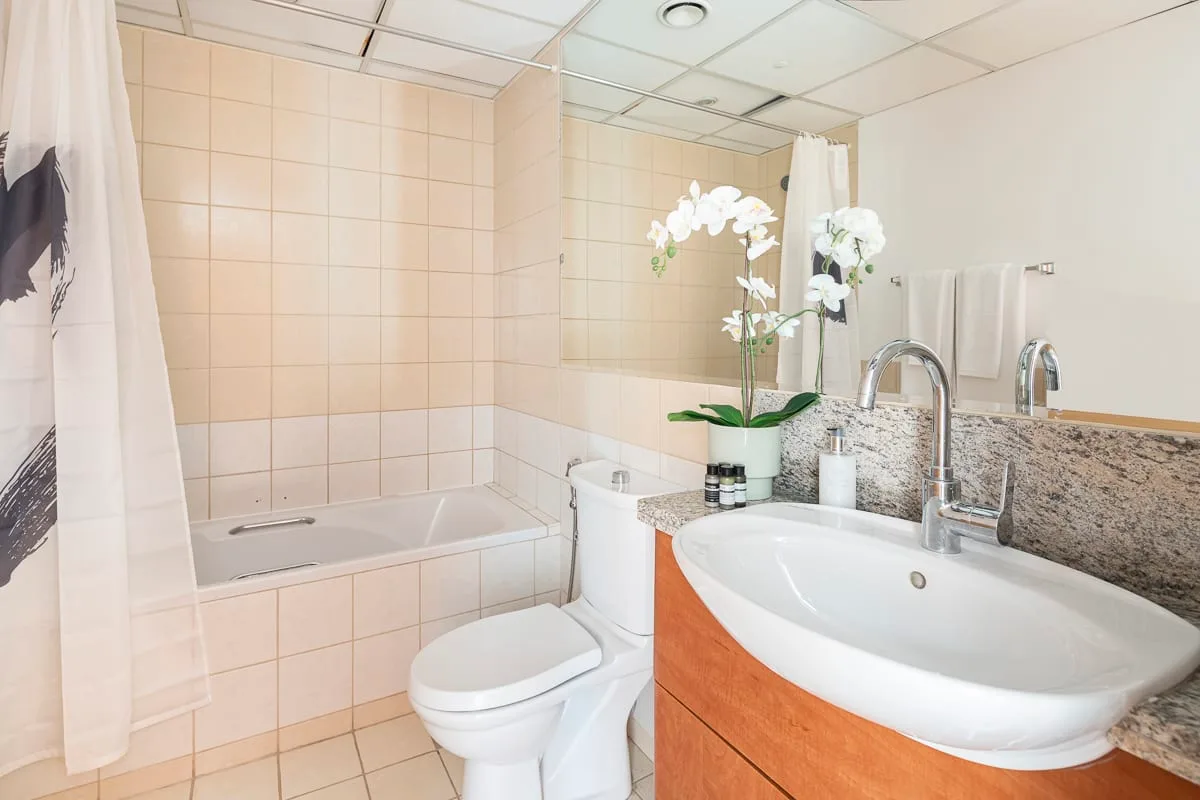 A tiled bathroom with a bathtub, toilet, and sink.