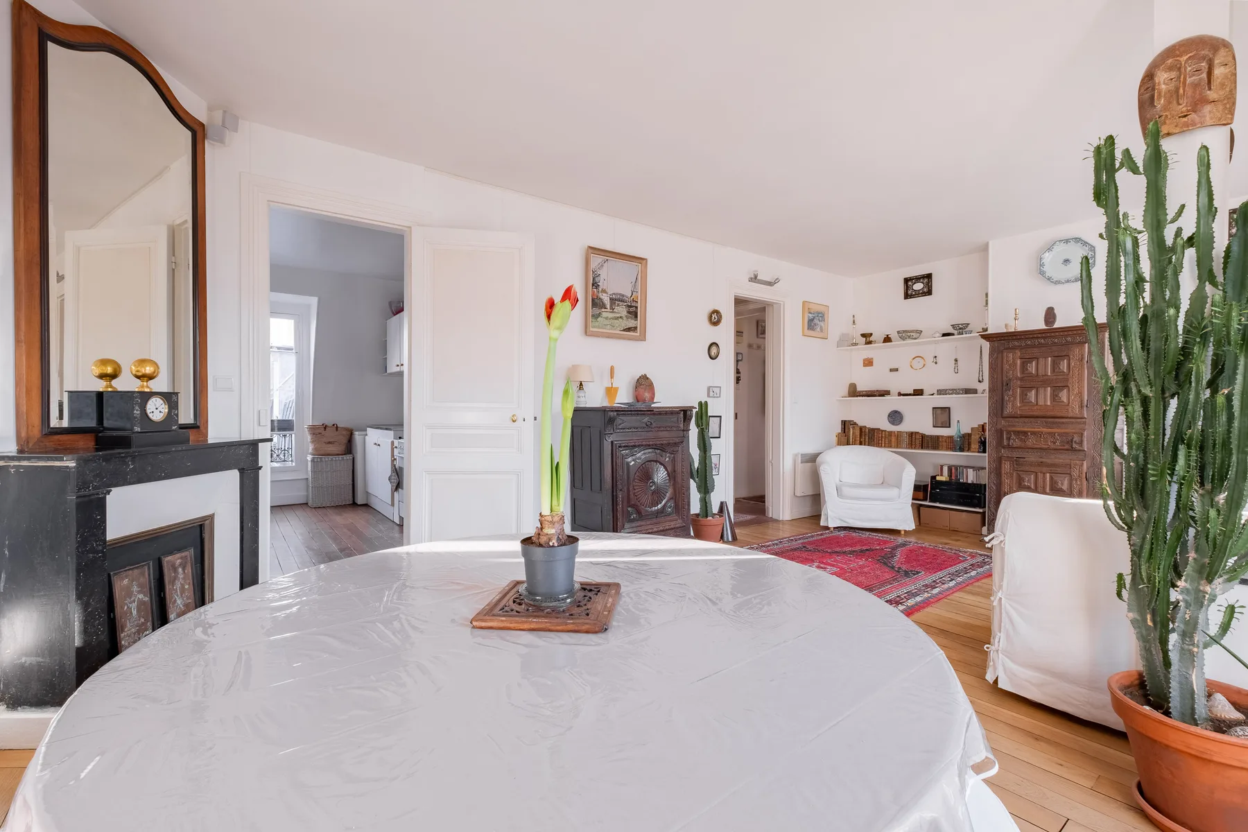 A bright living room with a round table, seating, and a fireplace.