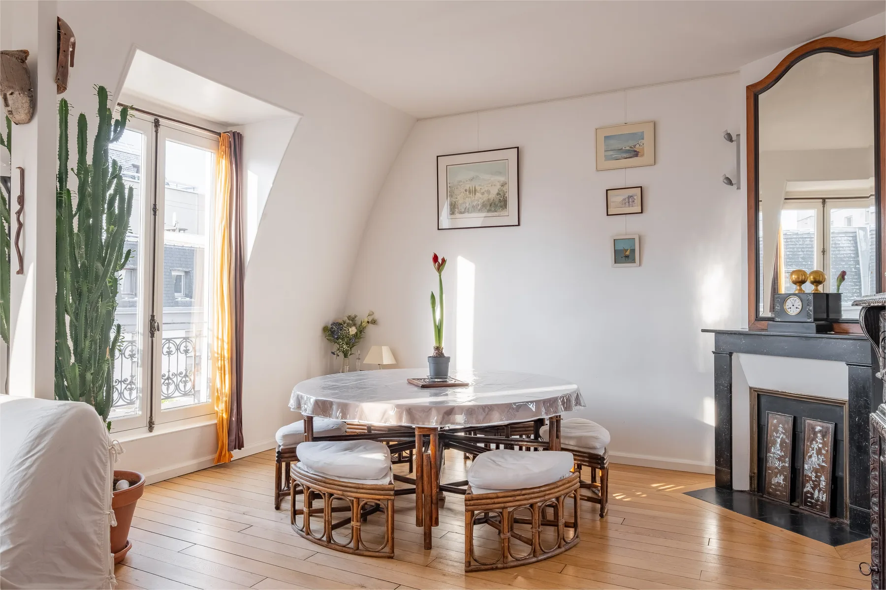 A bright dining area with a round table, chairs, and tall windows.