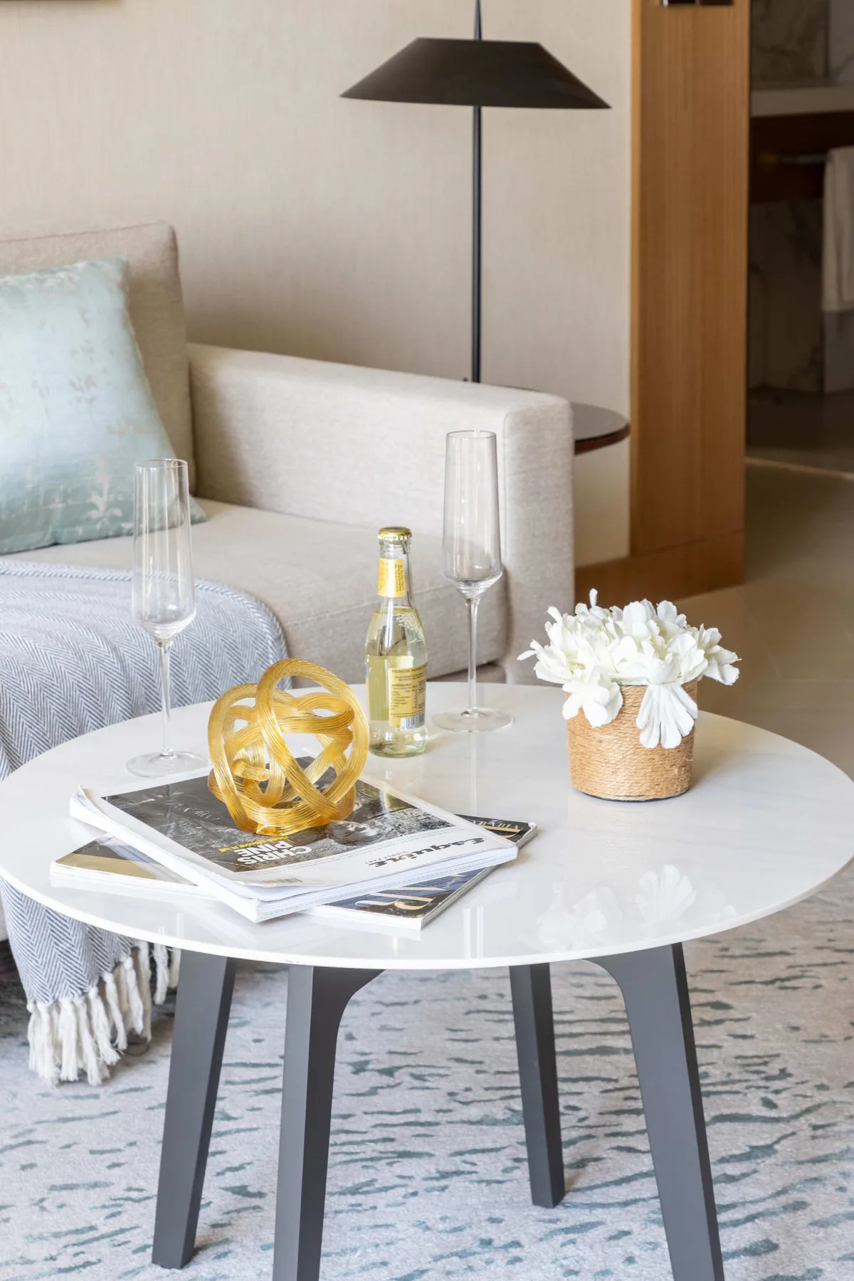 A living room seating area with a round coffee table and a floor lamp.
