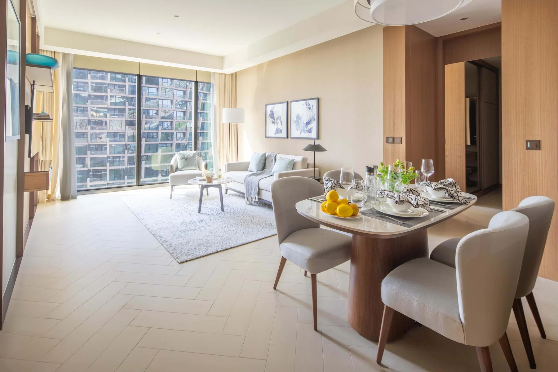 A bright living and dining area with large windows and a set dining table.