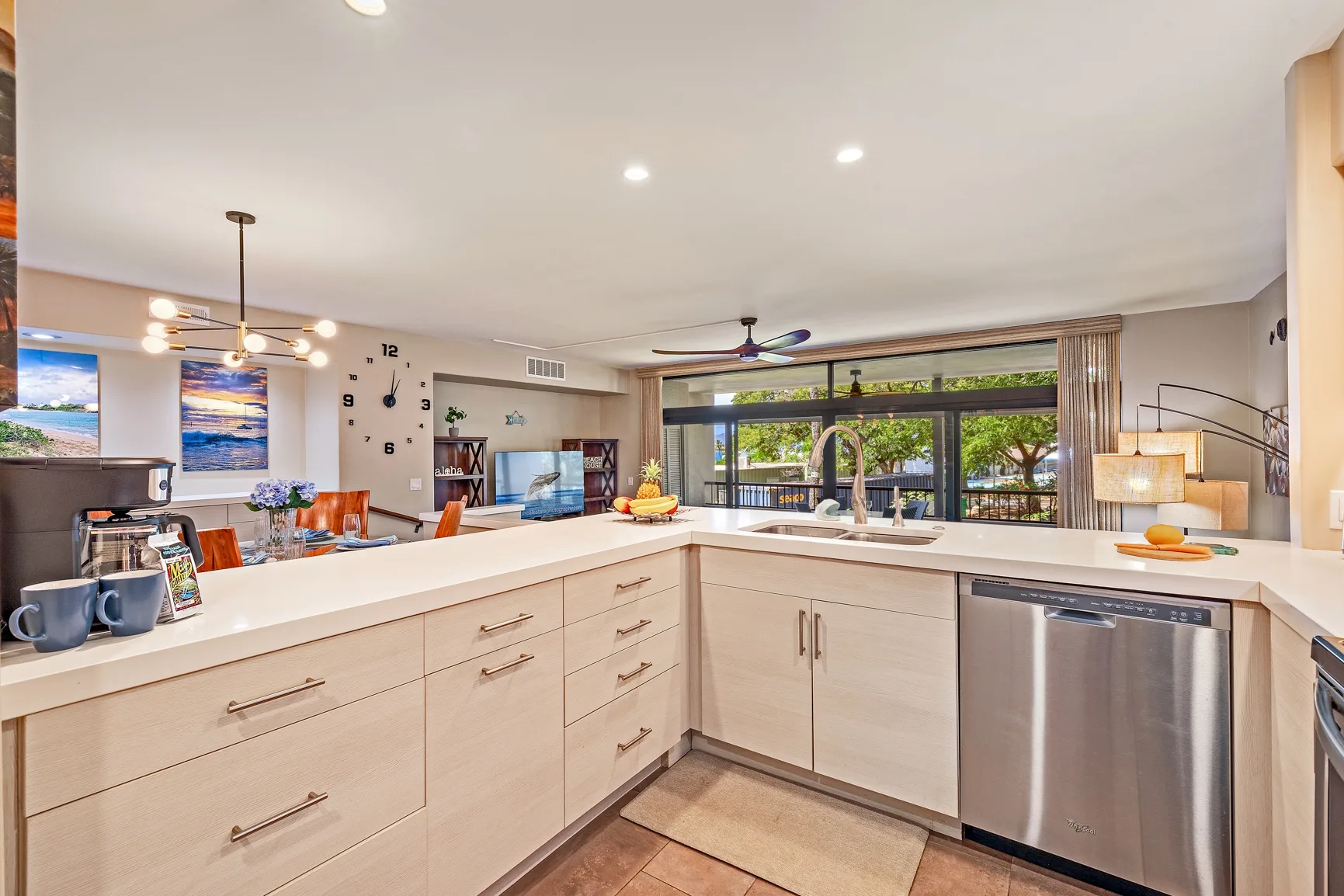 Una cocina luminosa con gabinetes claros, una amplia encimera y una ventana grande.