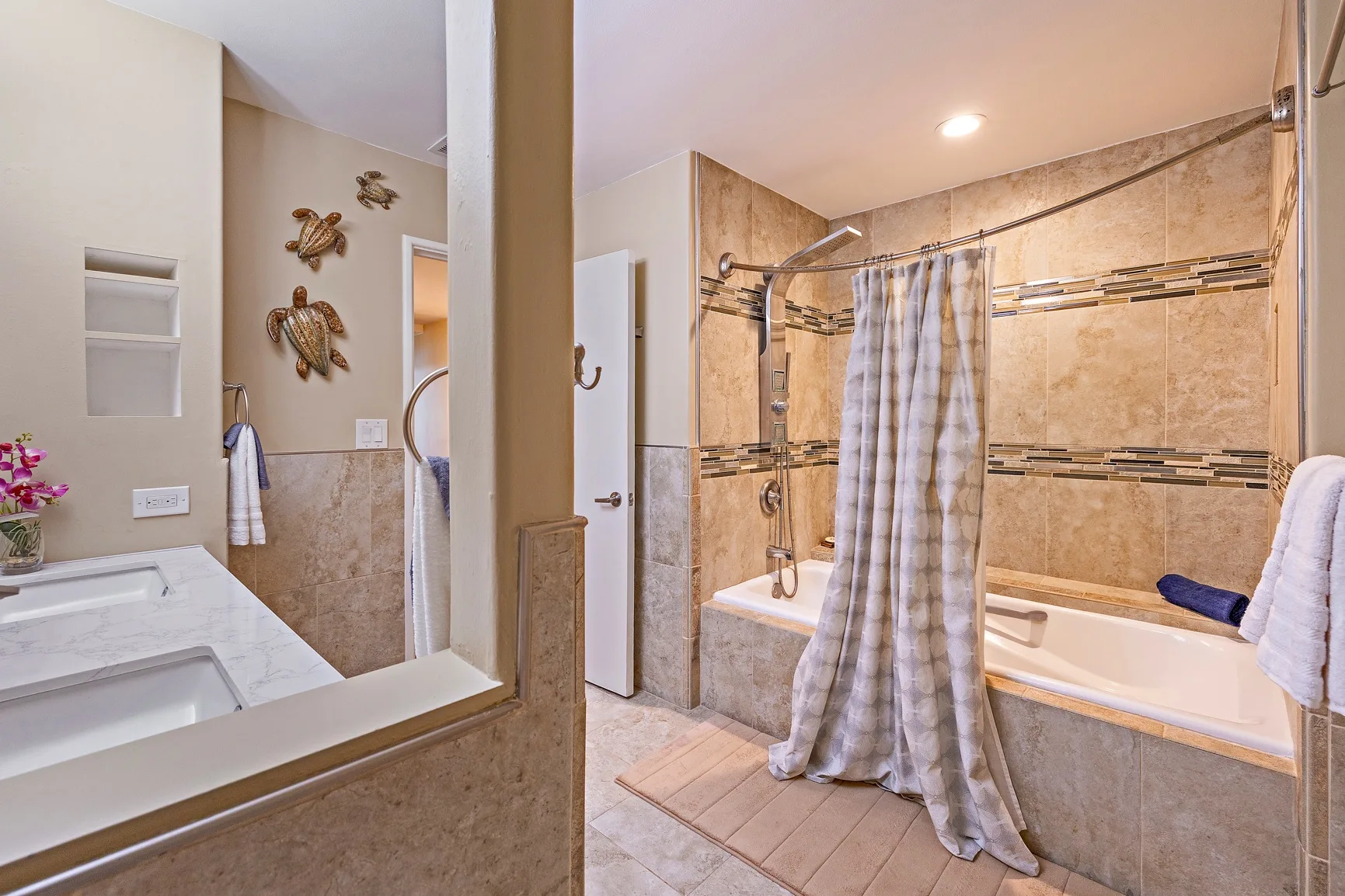 Un baño con bañera, cortina de ducha y un espejo grande.