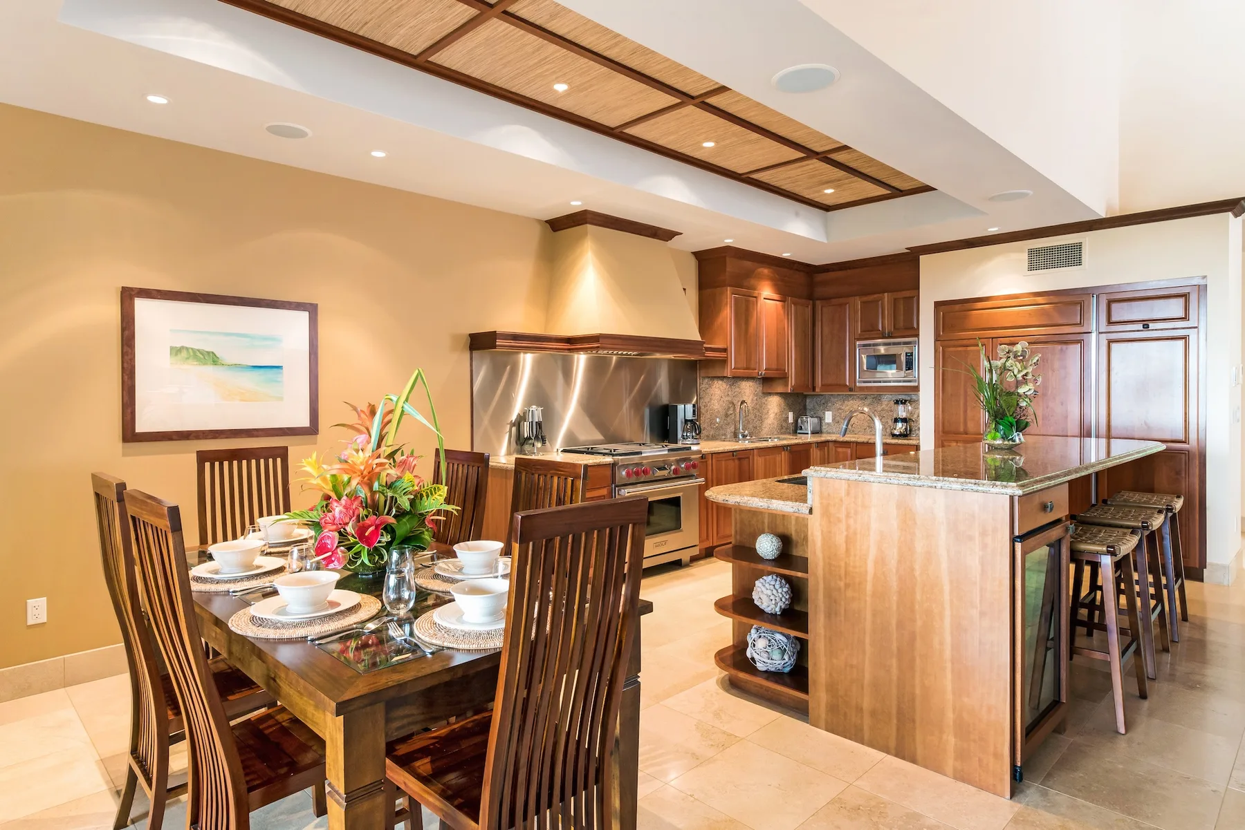 Un comedor se abre a una cocina con una isla central.