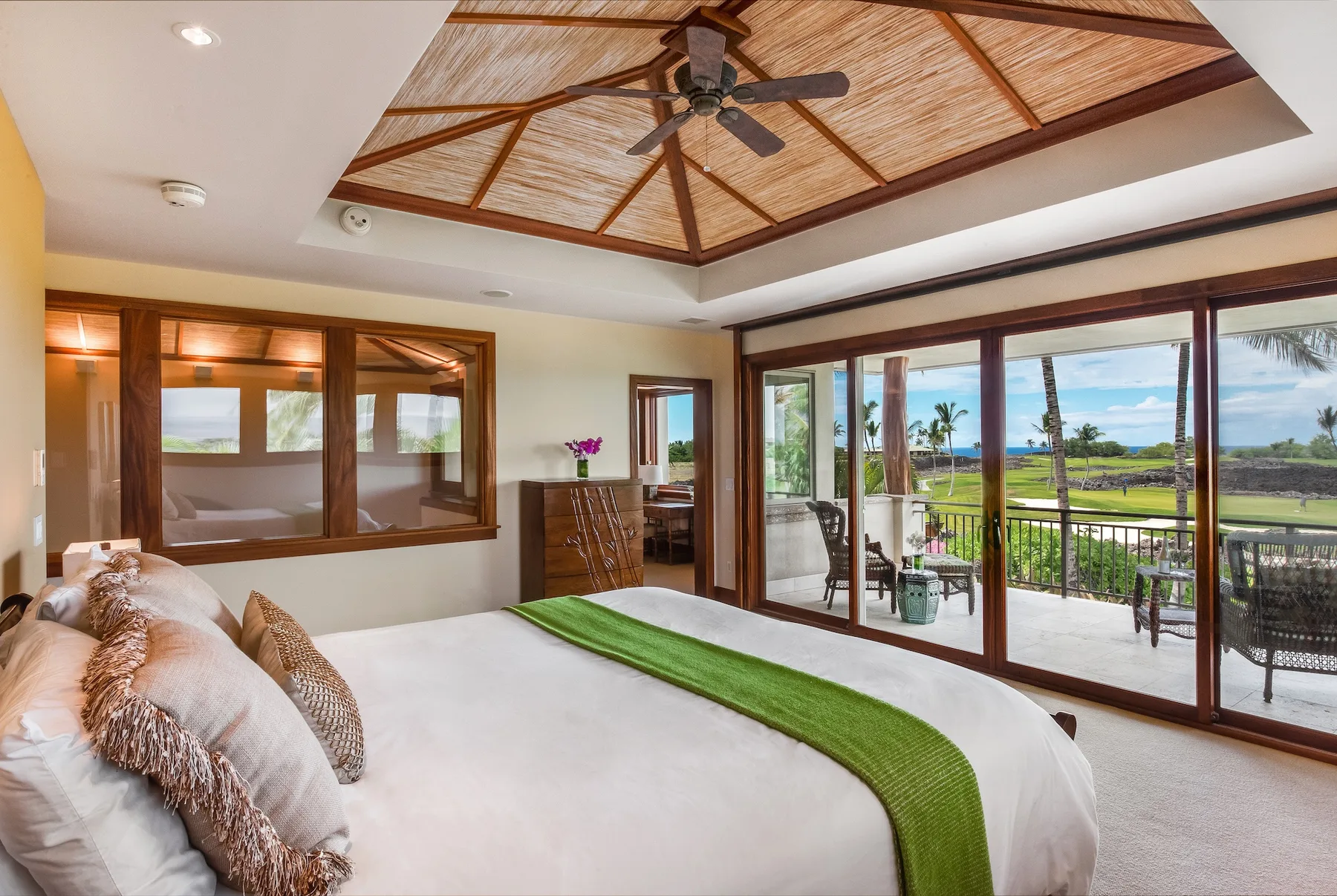 Un dormitorio con una cama, ventanas con marcos de madera y vista al balcón.