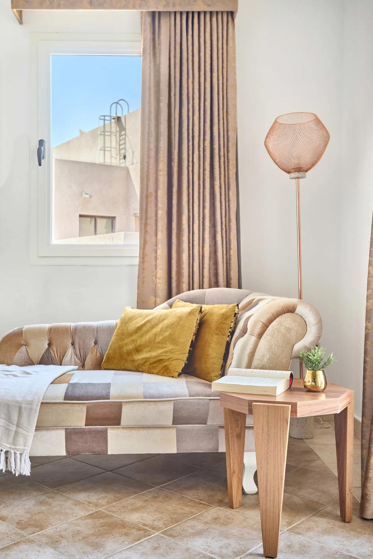 Una zona de estar con sofá, cortinas y una mesa pequeña.