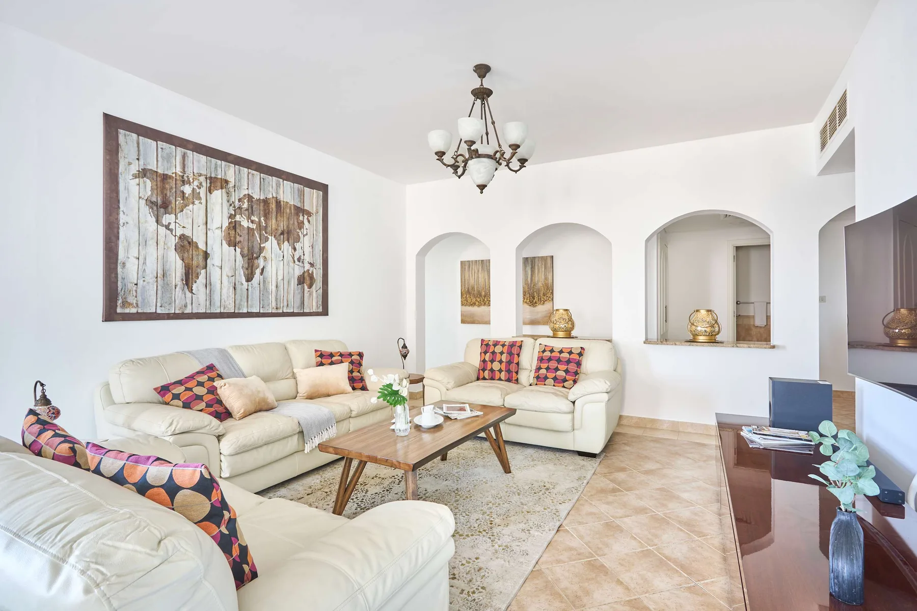 Una sala luminosa con asientos color crema alrededor de una mesa de centro de madera.