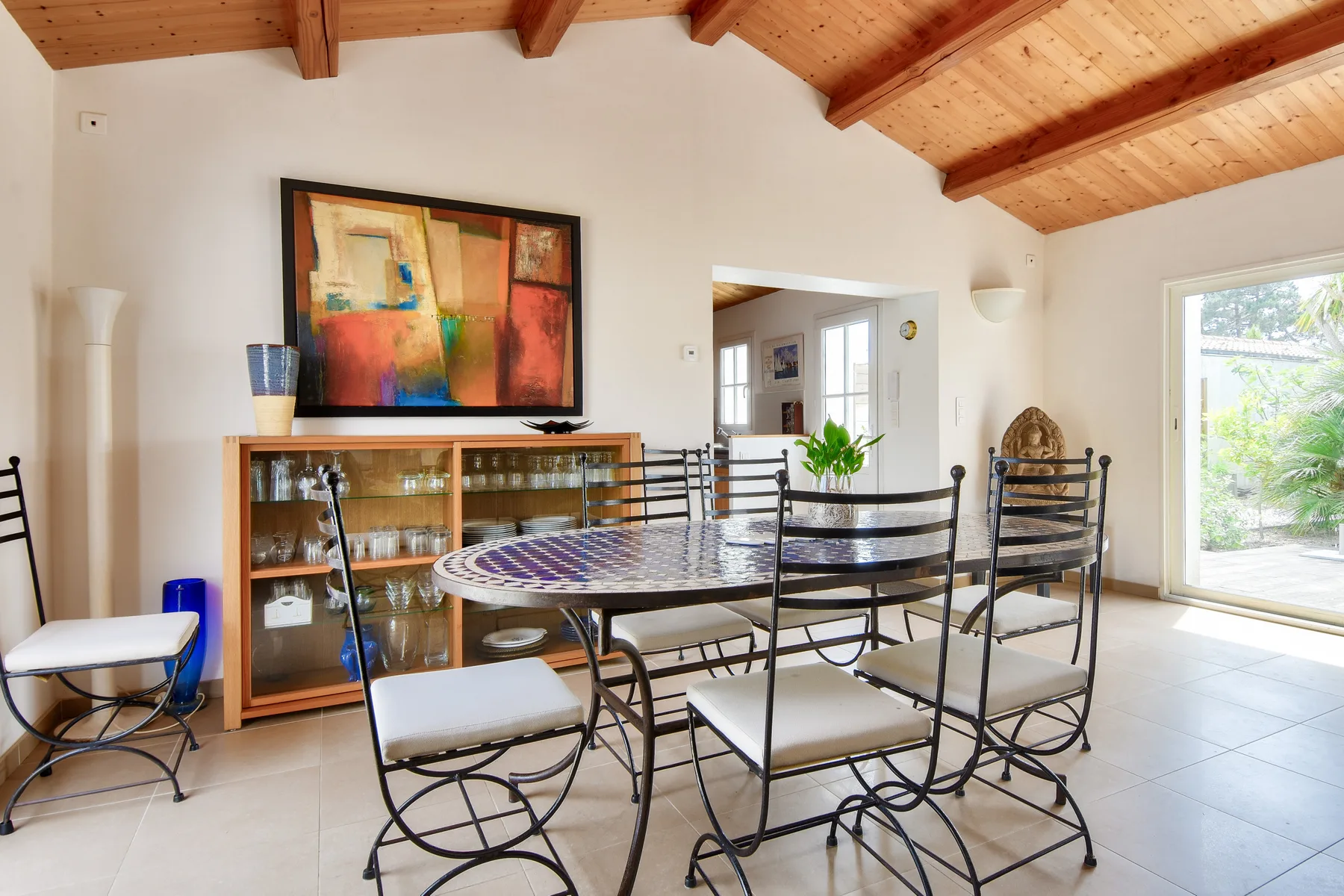 Dining area with a table, seating, and a wooden beam ceiling.
