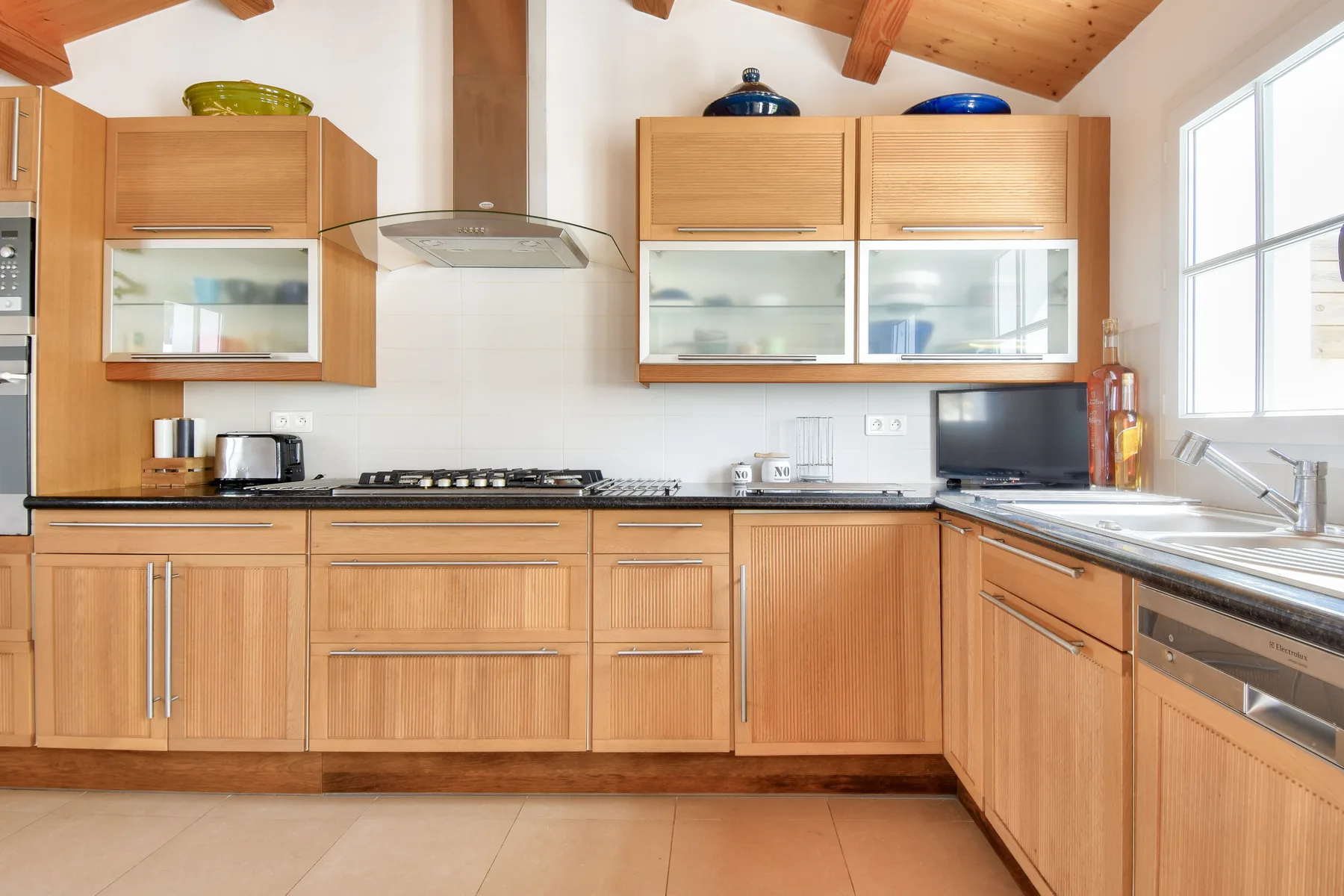 A bright kitchen with wooden cabinets and a countertop.