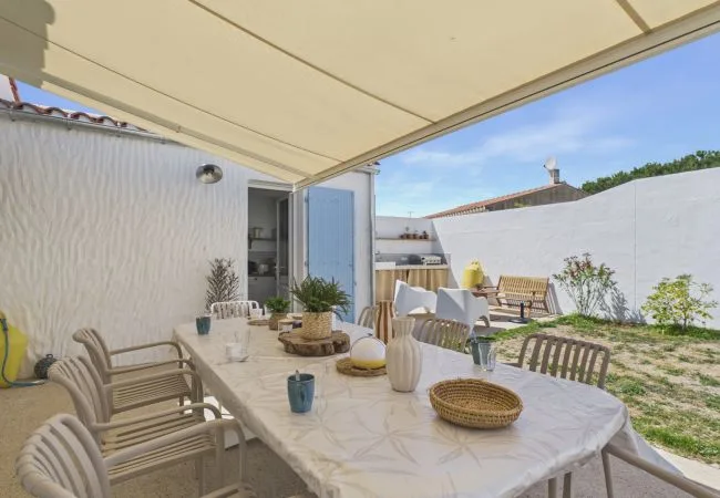 Outdoor patio dining area with a covered table and seating.