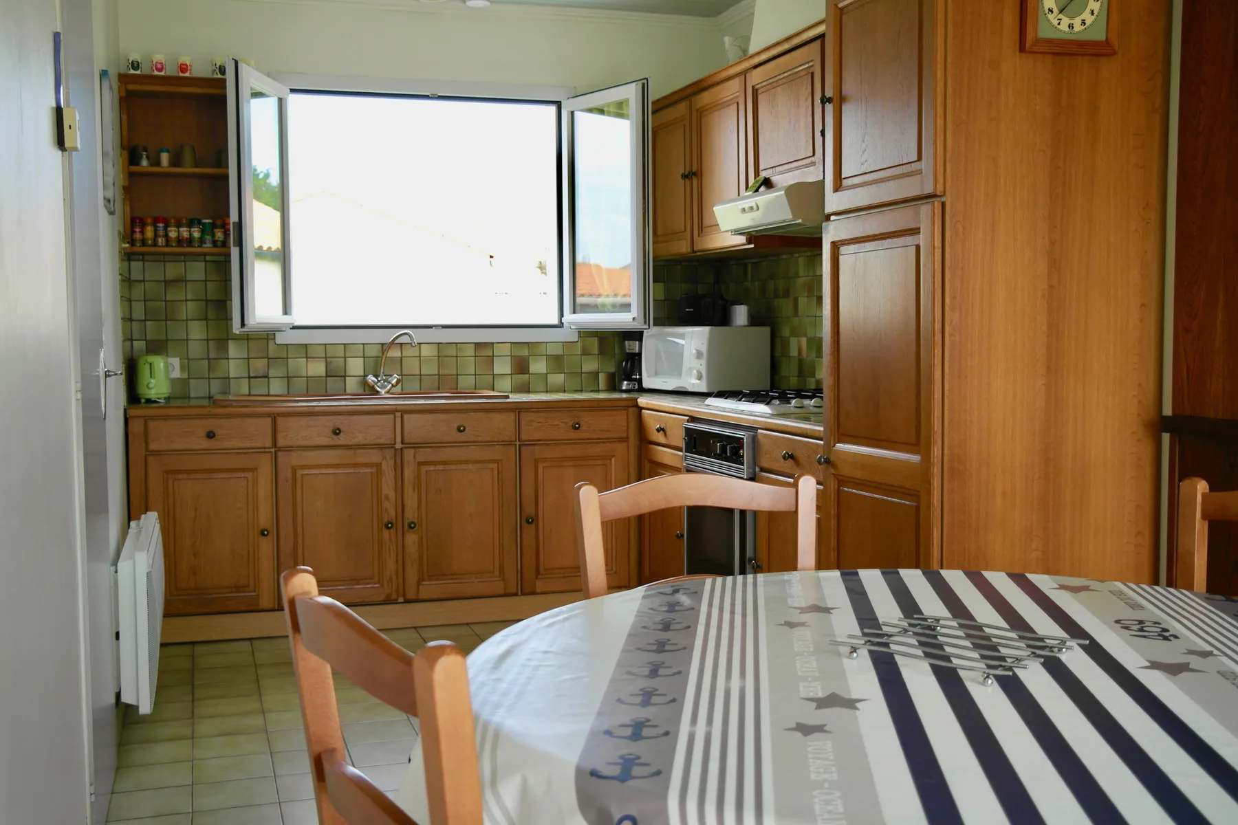 A kitchen with wooden cabinets and a dining table in the foreground.