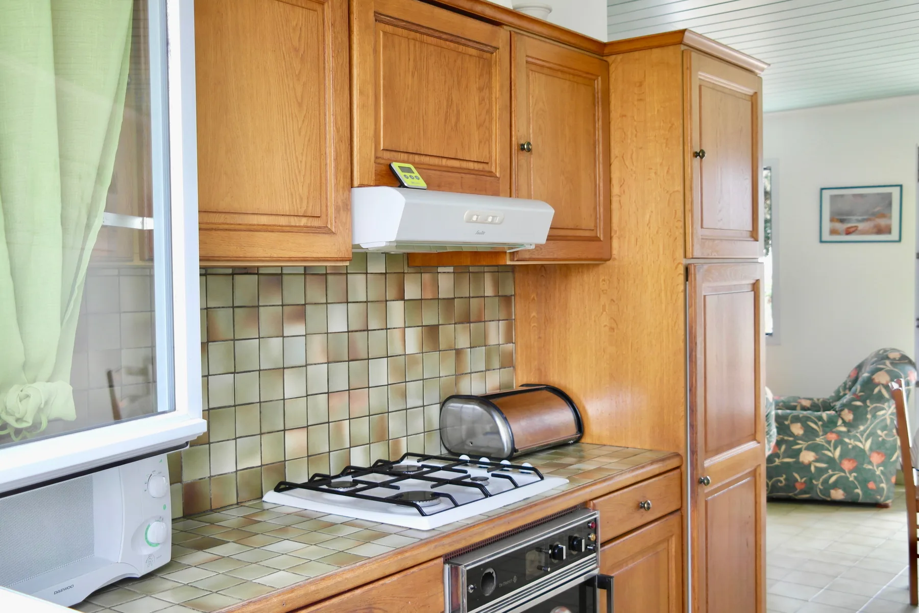 A kitchen with wooden cabinets and a gas cooktop.