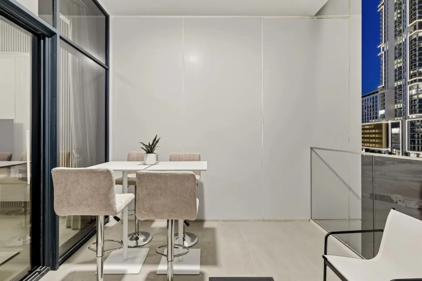 A compact dining area with a table and upholstered seating beside glass doors.