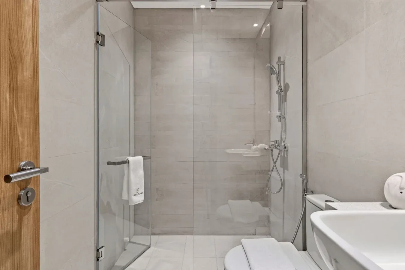 A tiled bathroom with a glass shower and bathtub.