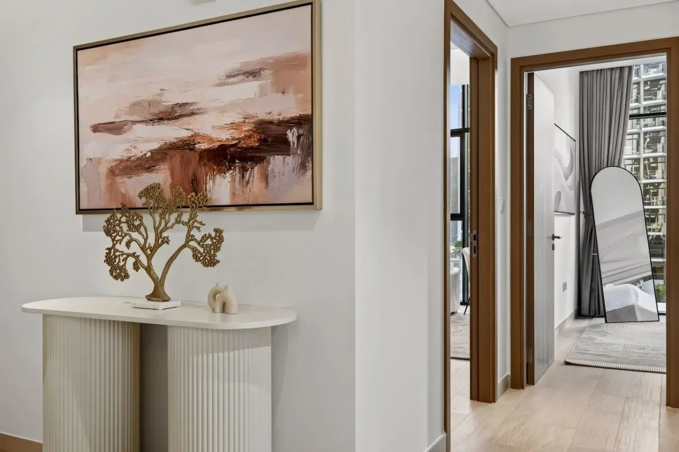 A bright interior hallway with an abstract painting above a console table.