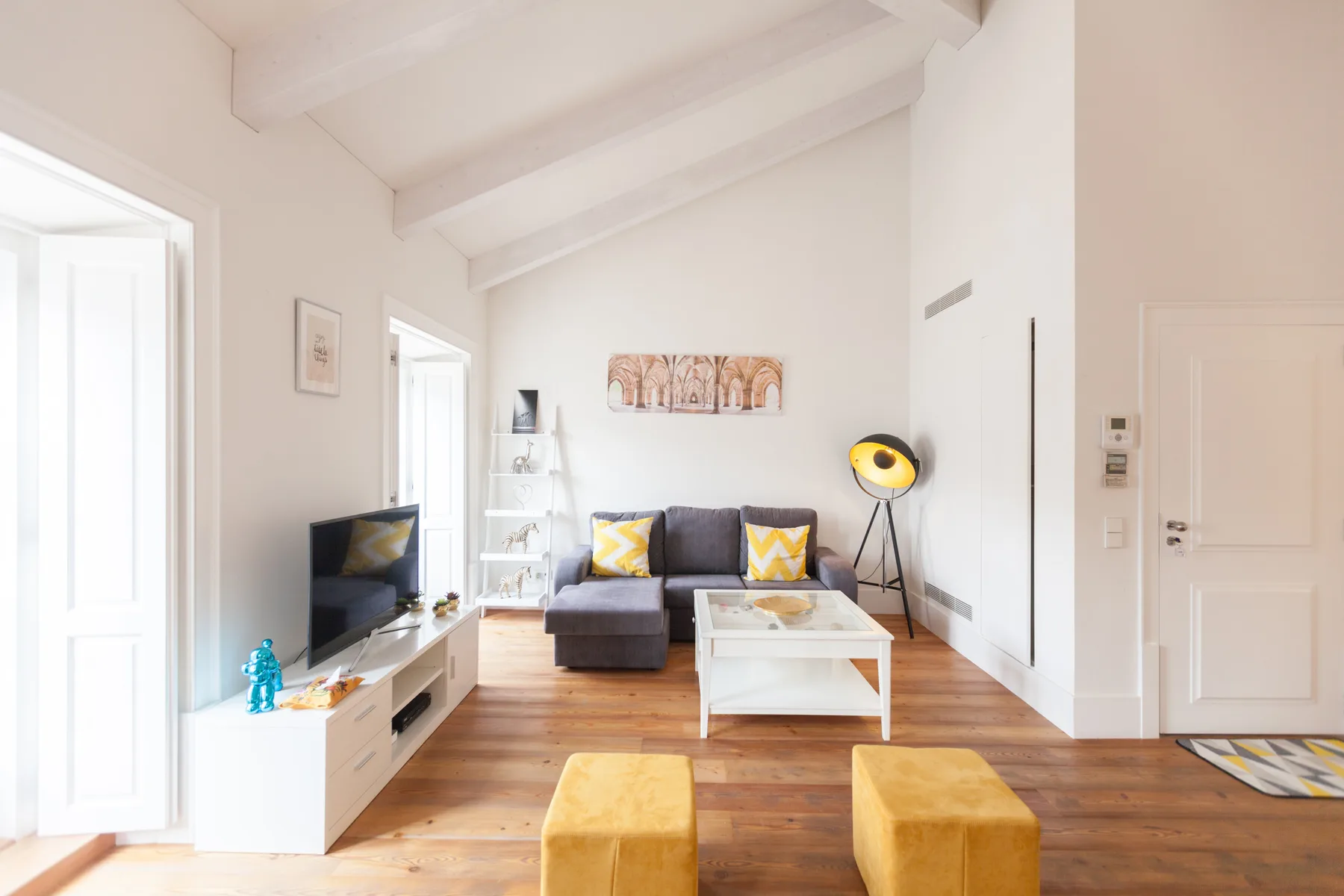 Una sala de estar luminosa con asientos, un televisor y una mesa de centro.