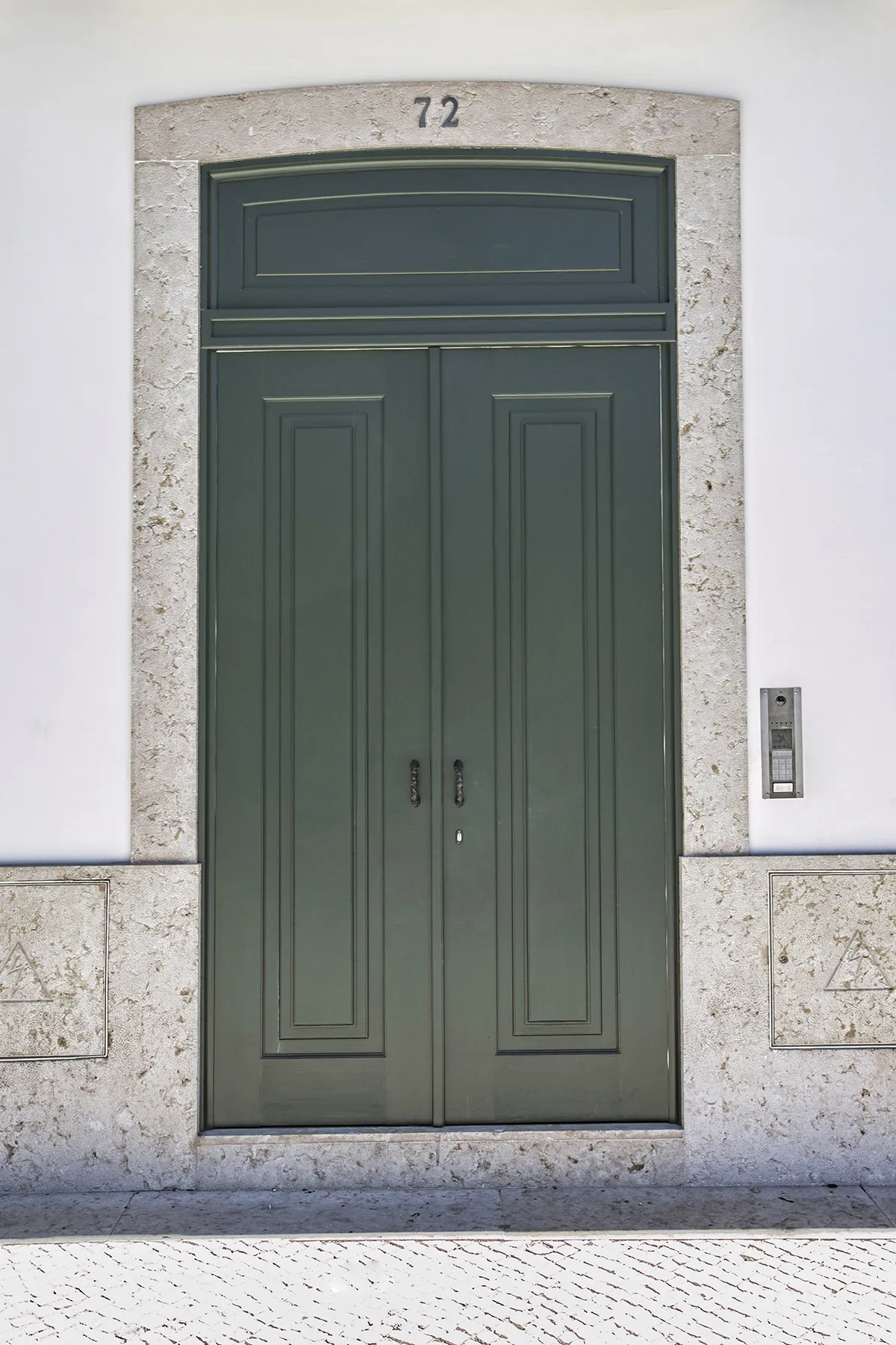 Una puerta de entrada verde oscuro está enmarcada por piedra clara.