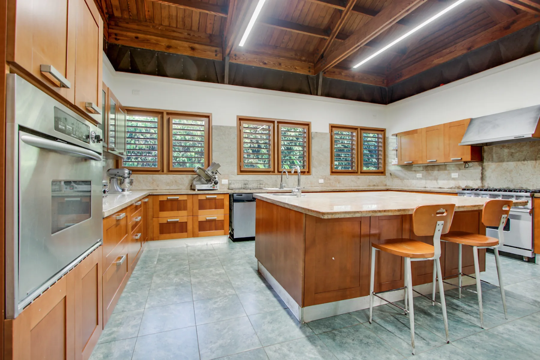 A spacious kitchen with wooden cabinets and a large central island.