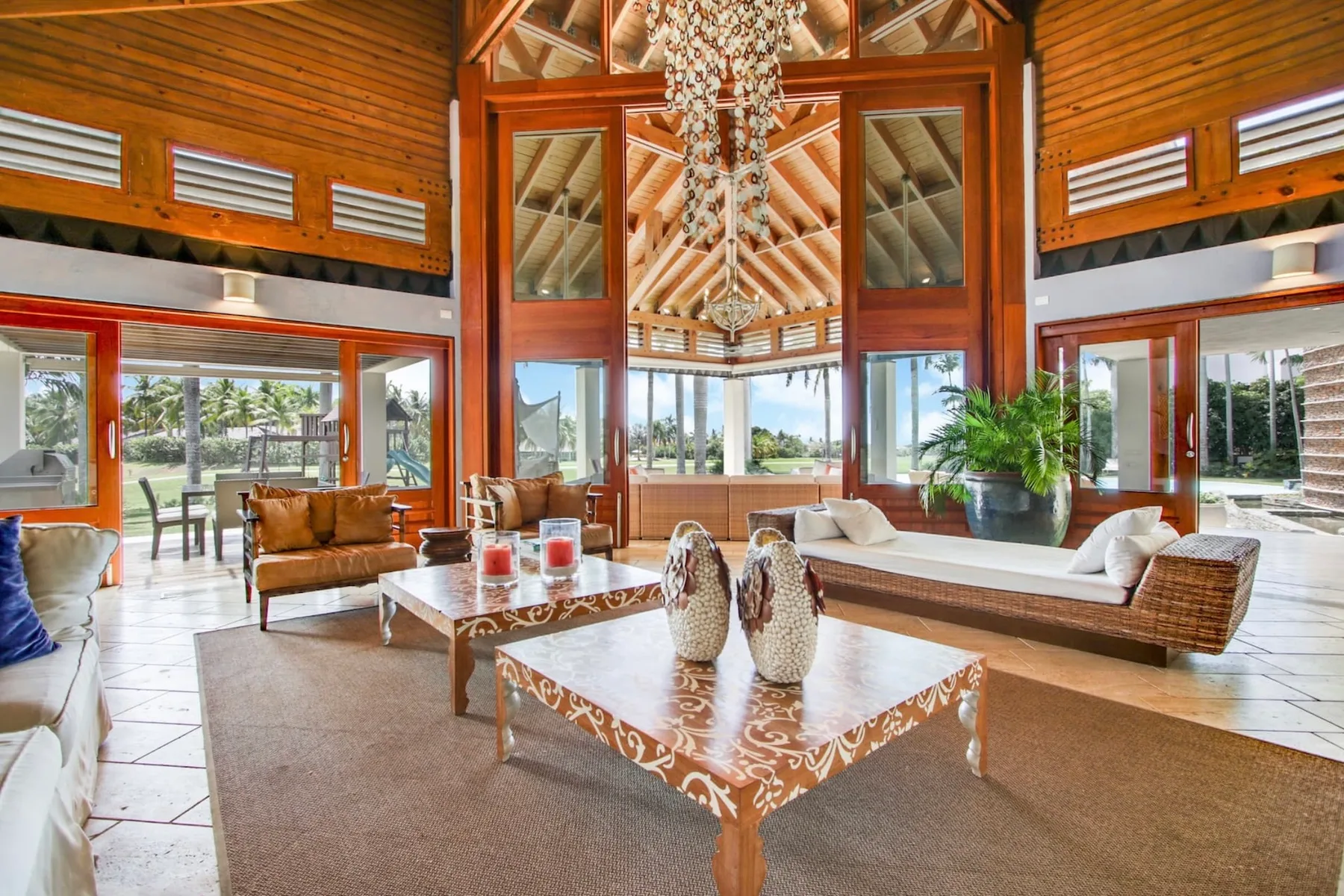 A spacious living room with seating, low tables, and large windows.
