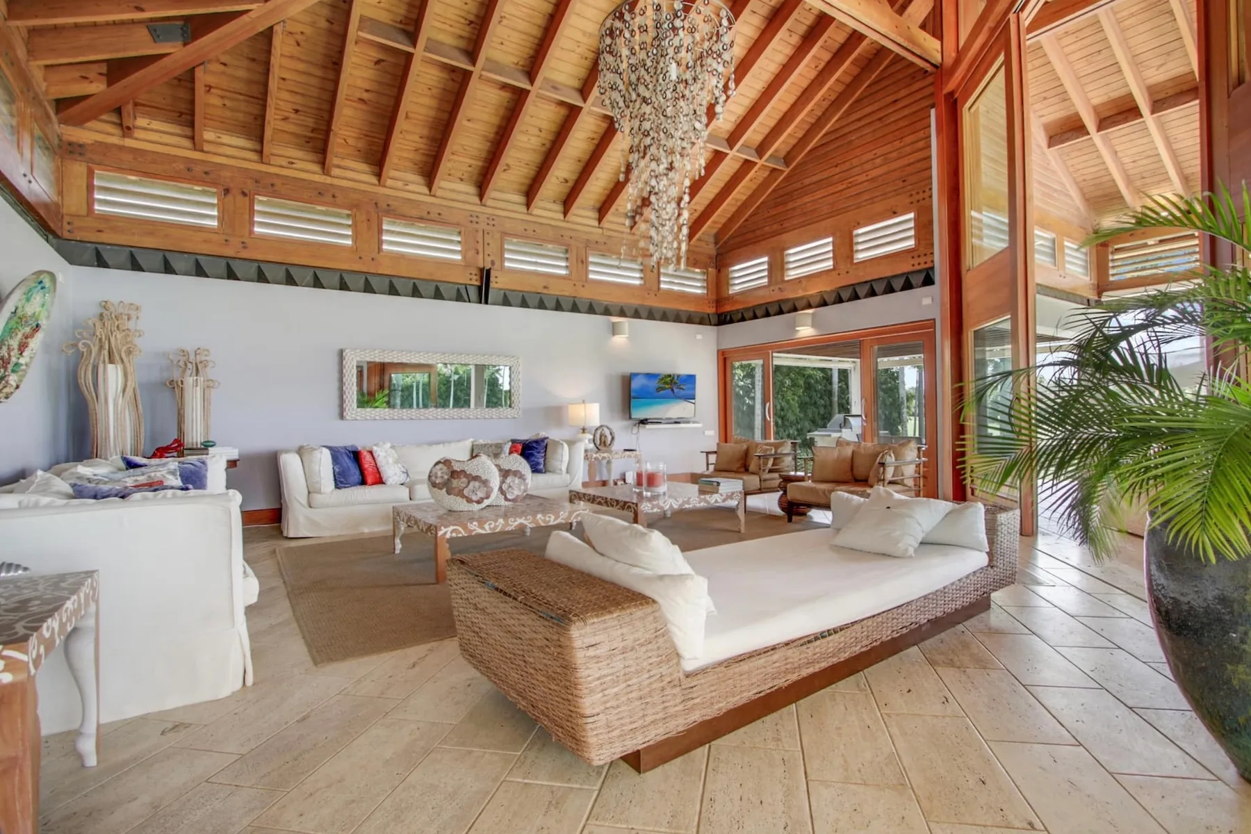 A spacious living room with seating beneath an exposed timber ceiling.
