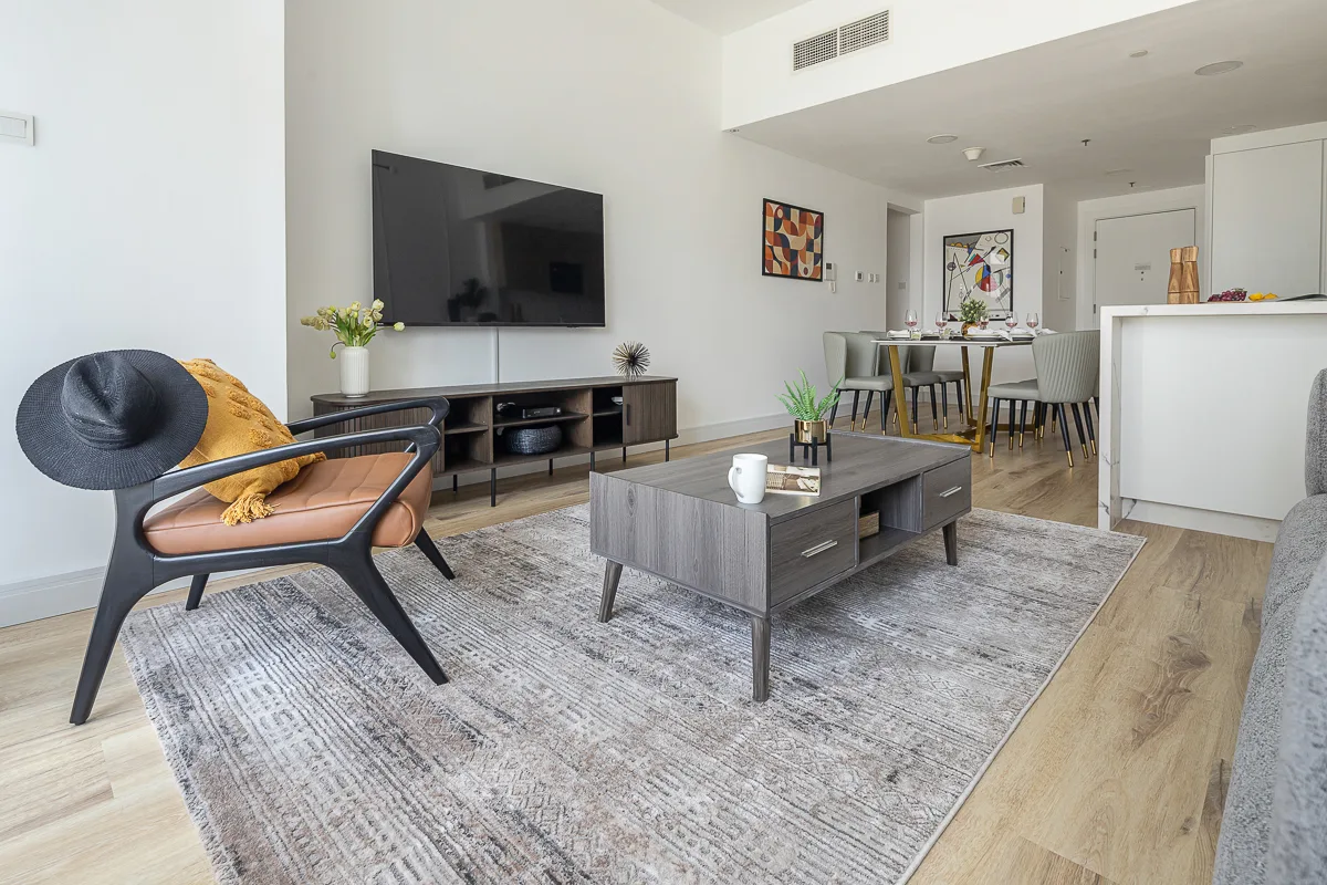 Una luminosa sala de estar y comedor con televisor, asientos y una mesa de comedor.