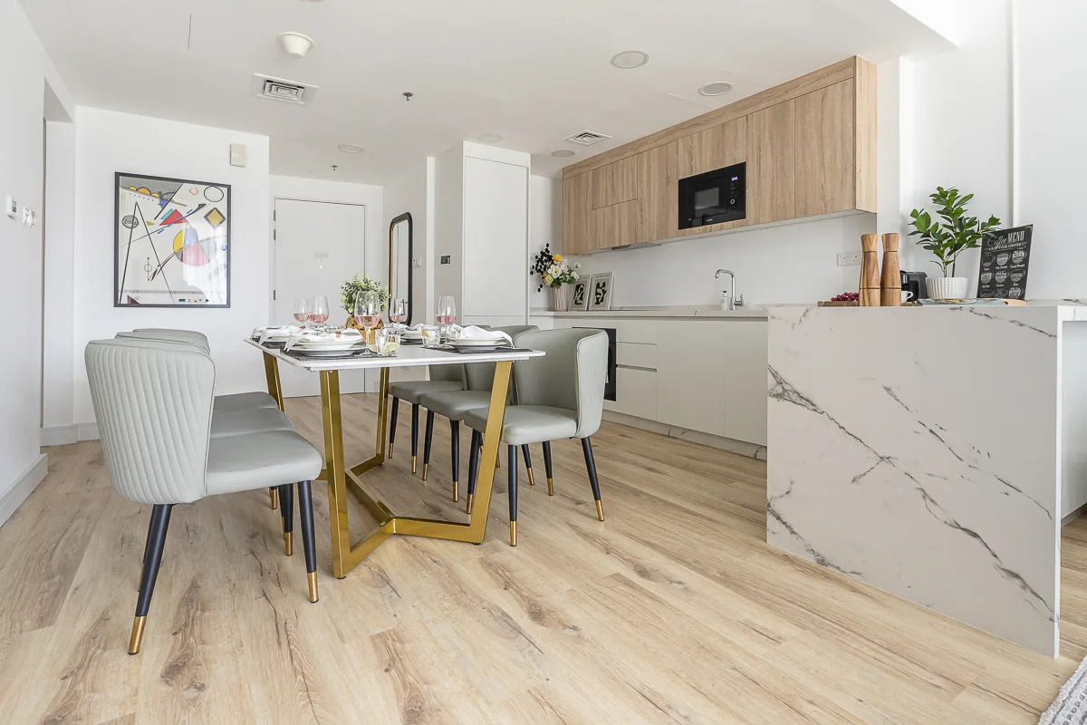 Comedor con la mesa puesta junto a una cocina moderna.