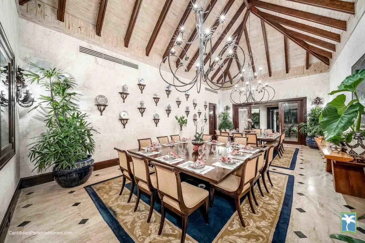 Un comedor formal con una mesa larga dispuesta bajo grandes lámparas de araña.