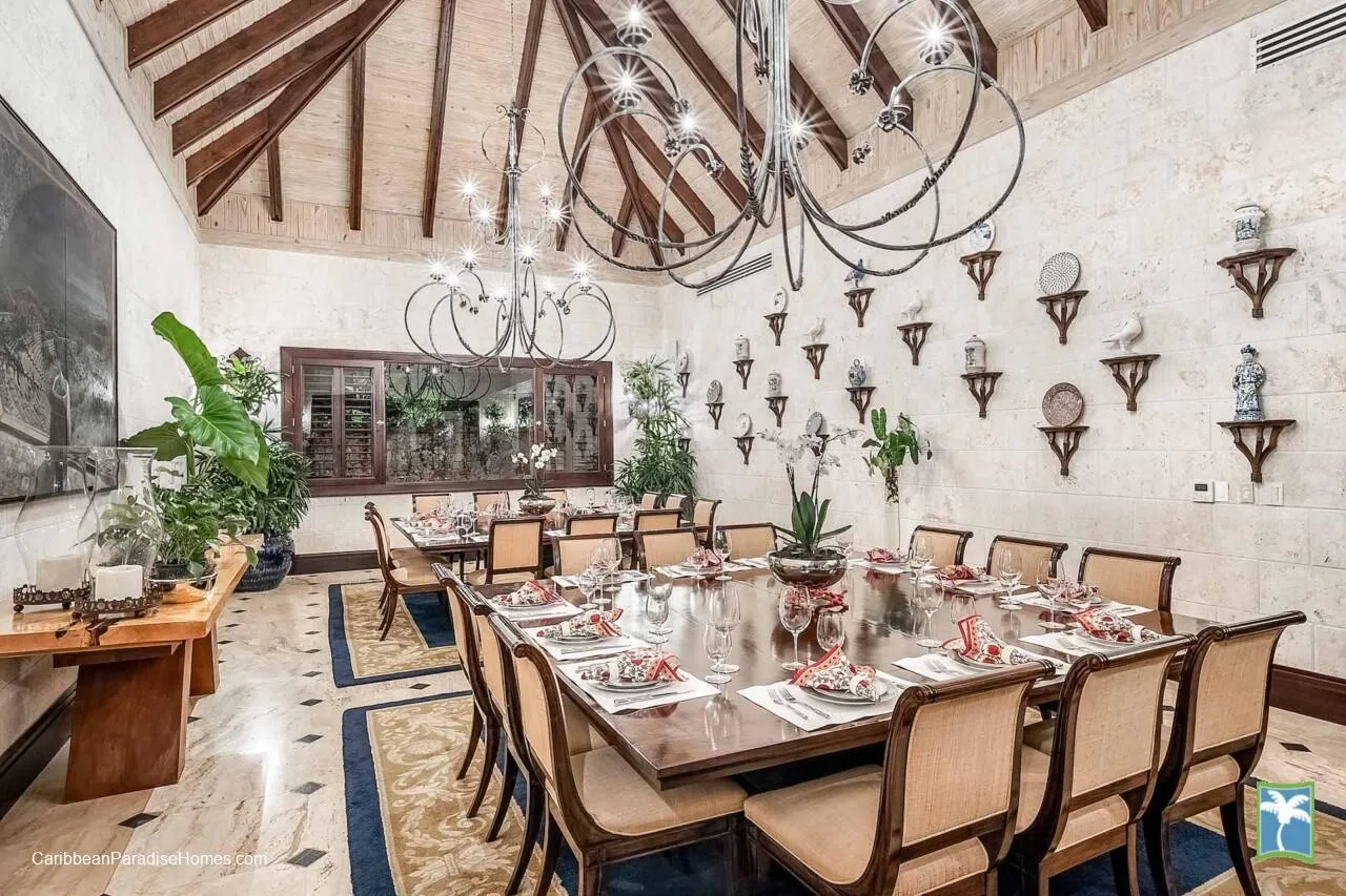 Un comedor formal con una mesa larga preparada para comer bajo lámparas colgantes.