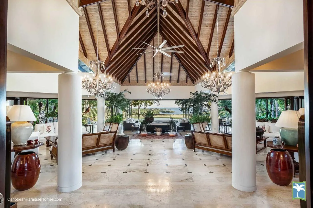 Un vestíbulo amplio con techo alto de madera, candelabros y asientos.