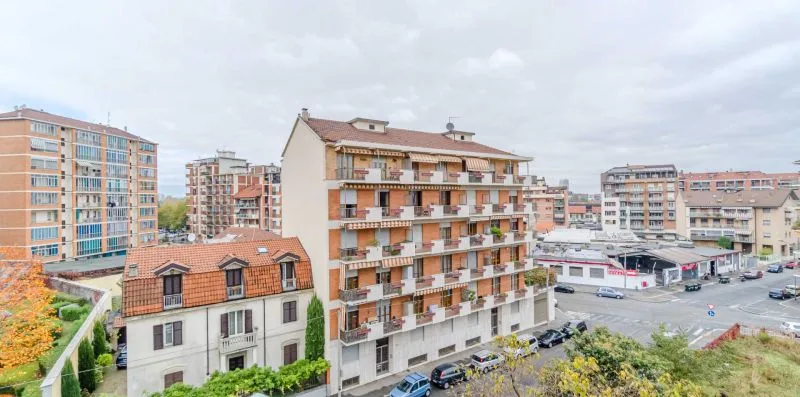 Una calle residencial con edificios de apartamentos y coches estacionados.